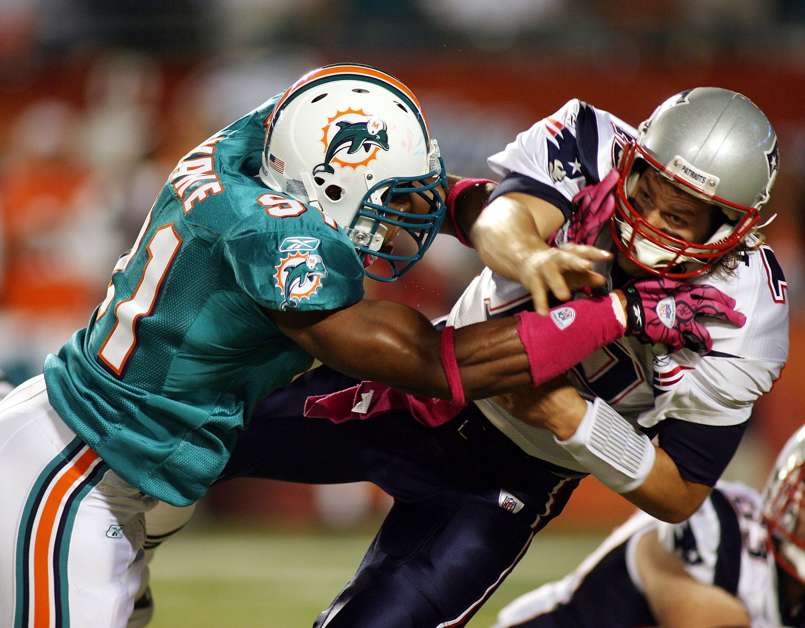 MIAMI - OCTOBER 04:  Quarterback Tom Brady #12 of the New England Patriots is preasures by linebacker Cameron Wake #91 of the Miami Dolphins at Sun Life Stadium on October 4, 2010 in Miami, Florida.  (Photo by Marc Serota/Getty Images)