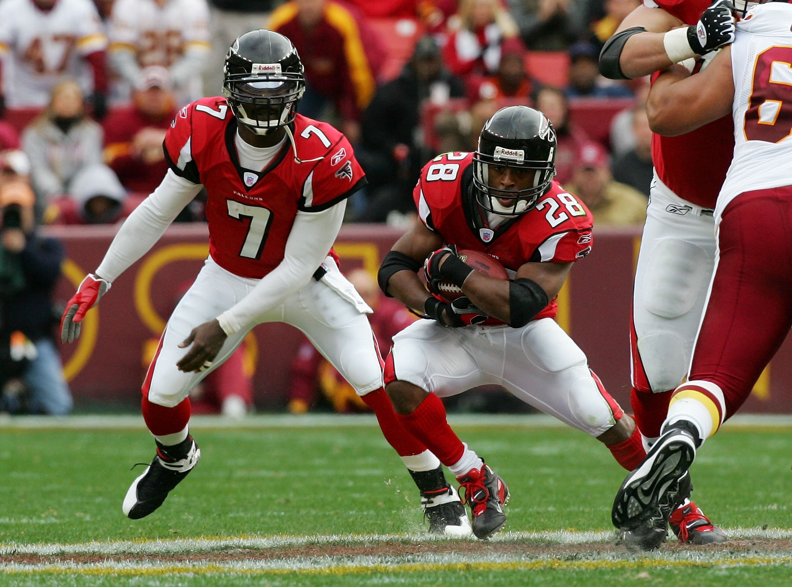 LANDOVER, MD - DECEMBER 03:  Warrick Dunn #28 of the Atlanta Falcons takes a hand off from teammate Michael Vick #7 against the Washington Redskins December 3, 2006 at FedEx Field in Landover, Maryland.  (Photo by Jim McIsaac/Getty Images)