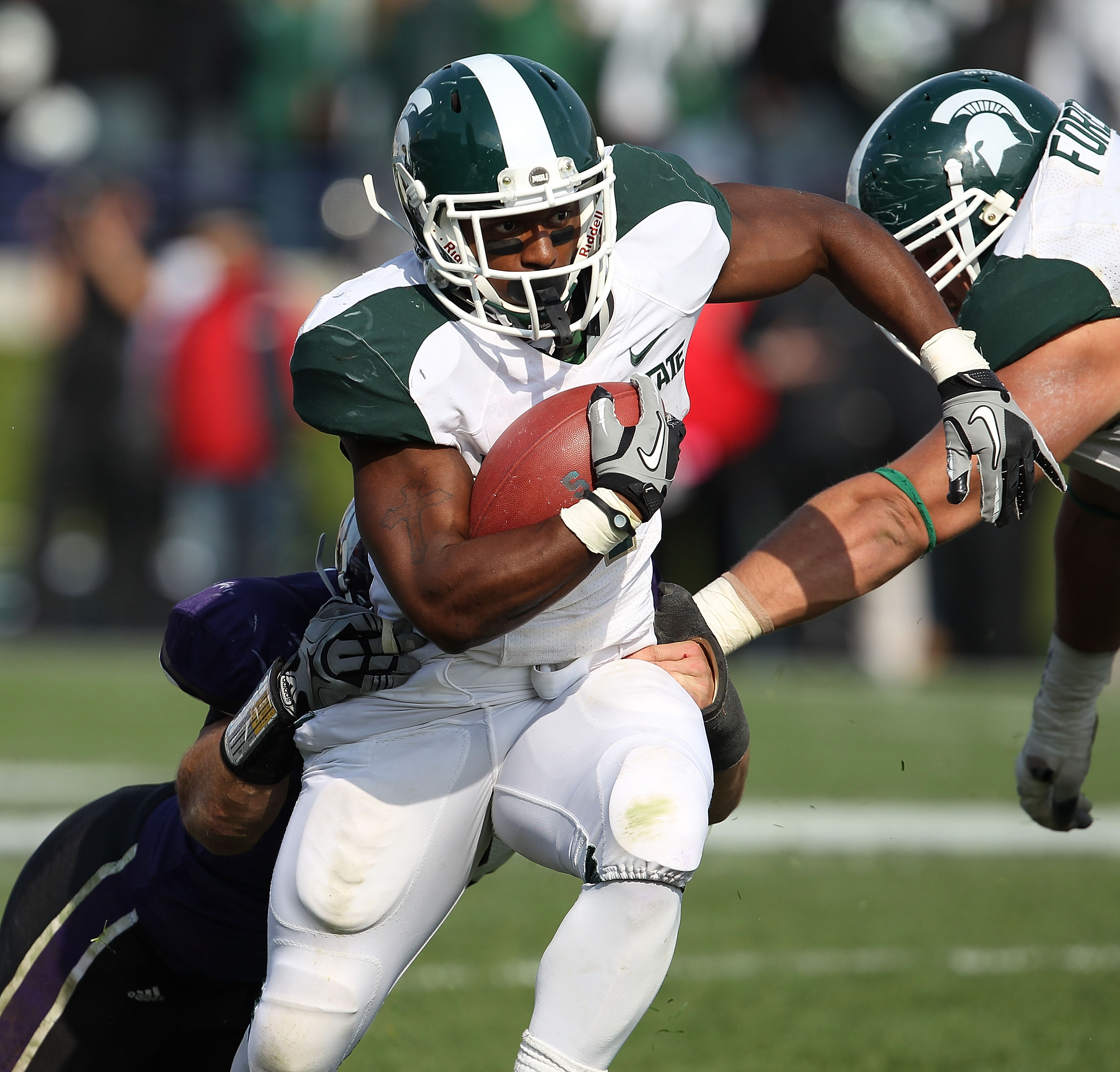 EVANSTON, IL - OCTOBER 23: Edwin Baker #4 of the Michigan State Spartans breaks away from Brian Peters #10 of the Northwestern Wildcats at Ryan Field on October 23, 2010 in Evanston, Illinois. Michigan State defeated Northwestern 35-27.  (Photo by Jonatha