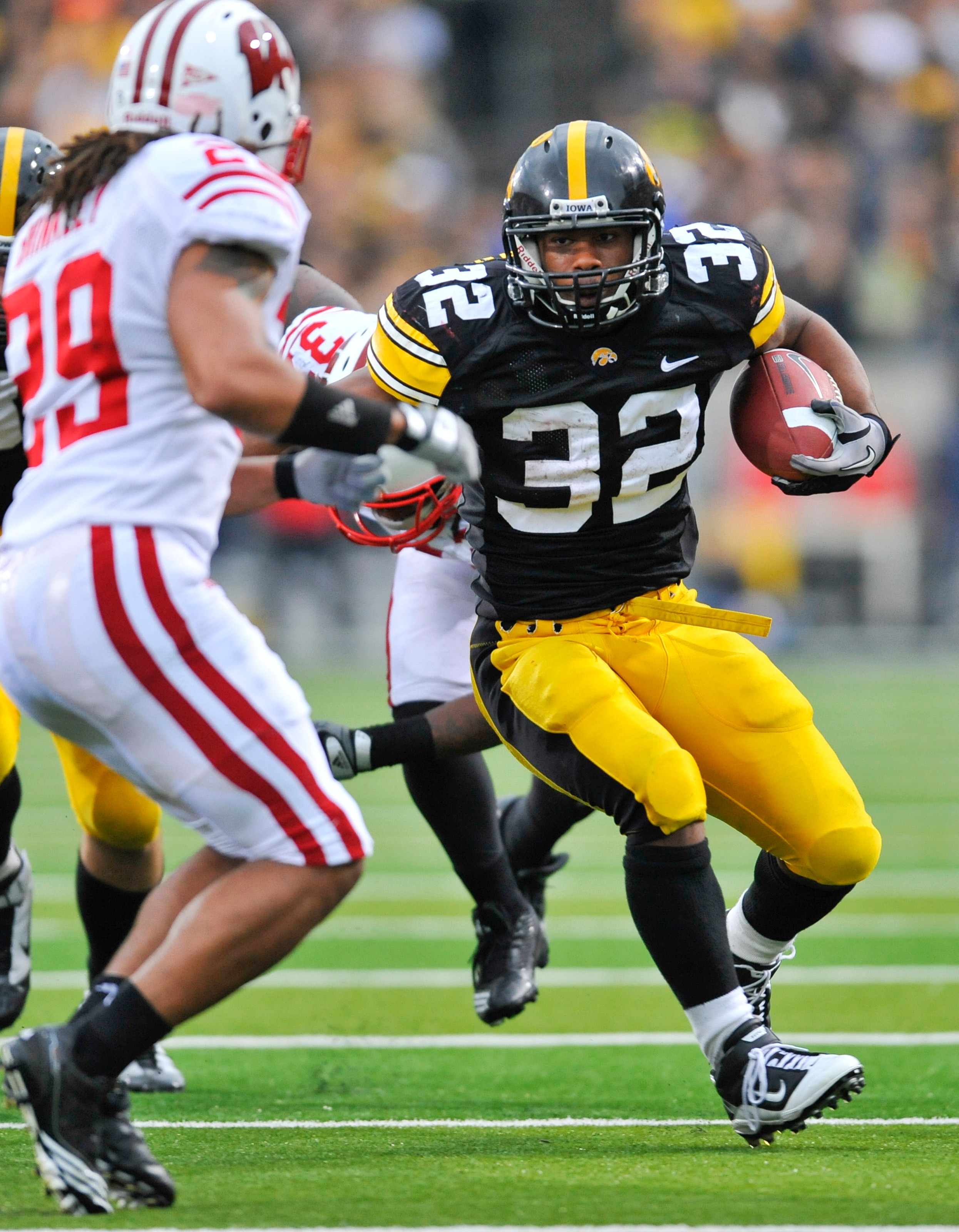 IOWA CITY, IA - OCTOBER 23- Defensive back Niles Brinkley #29 of the Wisconsin Badgers puts pressure on running back Adam Robinson #32 of the University of Iowa Hawkeyes as he rushes for yards during the second half of play at Kinnick Stadium on October 2