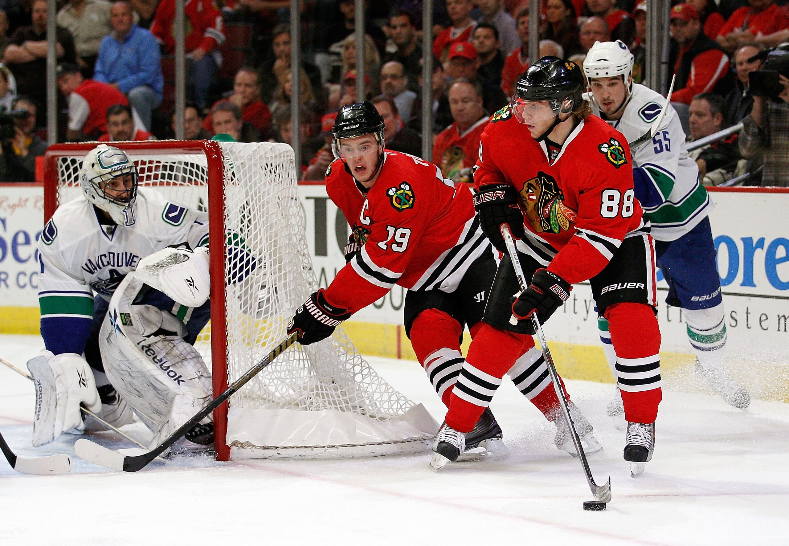 CHICAGO - MAY 03: Patrick Kane #88 of the Chicago Blackhawks looks to pass the puck past teammate Jonathan Toews #19 as Shane O'Brien #55 of the Vancouver Canucks closes in and Roberto Luongo #1 watches the play in Game Two of the Western Conference Semif