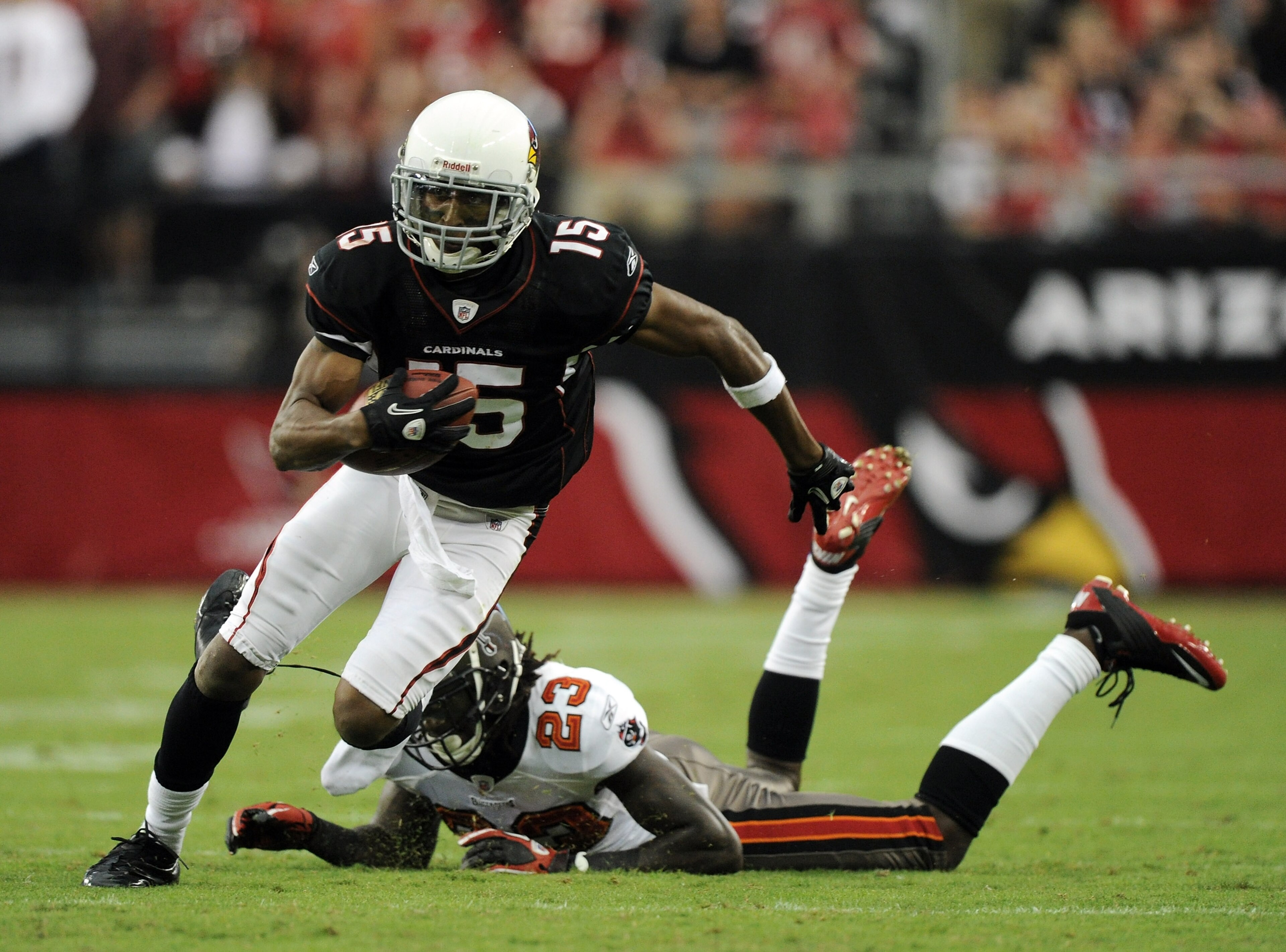 GLENDALE, AZ - OCTOBER 31: Steve Breaston #15 of the Arizona Cardinals loses a shoe as he eludes the tackle from Myron Lewis #23 of the Tampa Bay Buccaneers during the fourth quarter at University of Phoenix Stadium on October 31, 2010 in Glendale, Arizo GLENDALE, AZ - OCTOBER 31: Steve Breaston #15 of the Arizona Cardinals loses a shoe as he eludes the tackle from Myron Lewis #23 of the Tampa Bay Buccaneers during the fourth quarter at University of Phoenix Stadium on October 31, 2010 in Glendale, Arizo