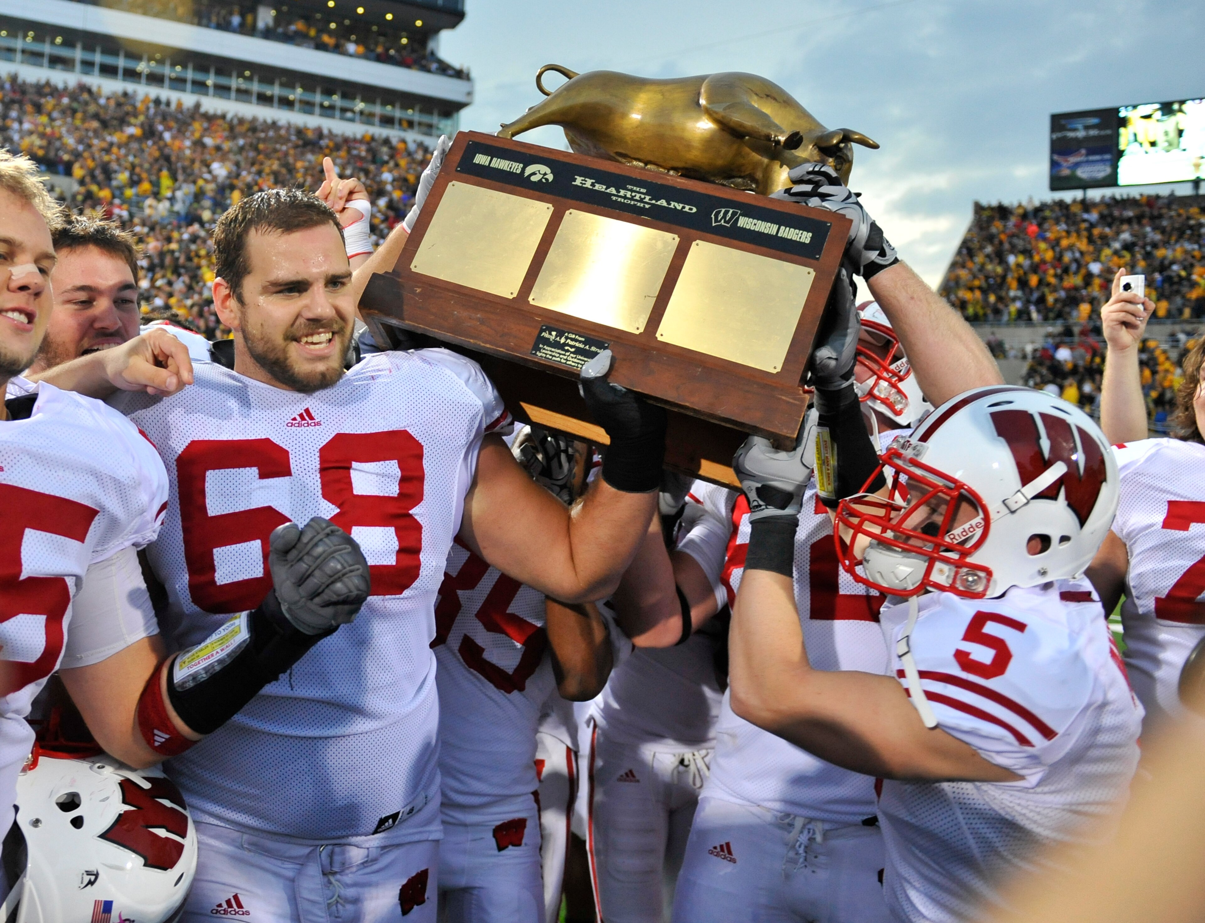 IOWA CITY, IA - OCTOBER 23: Offensive lineman Gabe Carimi #68 for the Wisconsin Badger holds the Heartland Trophy with his teammates as they celebrate their victory of the University of Iowa Hawkeyes at Kinnick Stadium on October 23, 2010 in Iowa City, Io