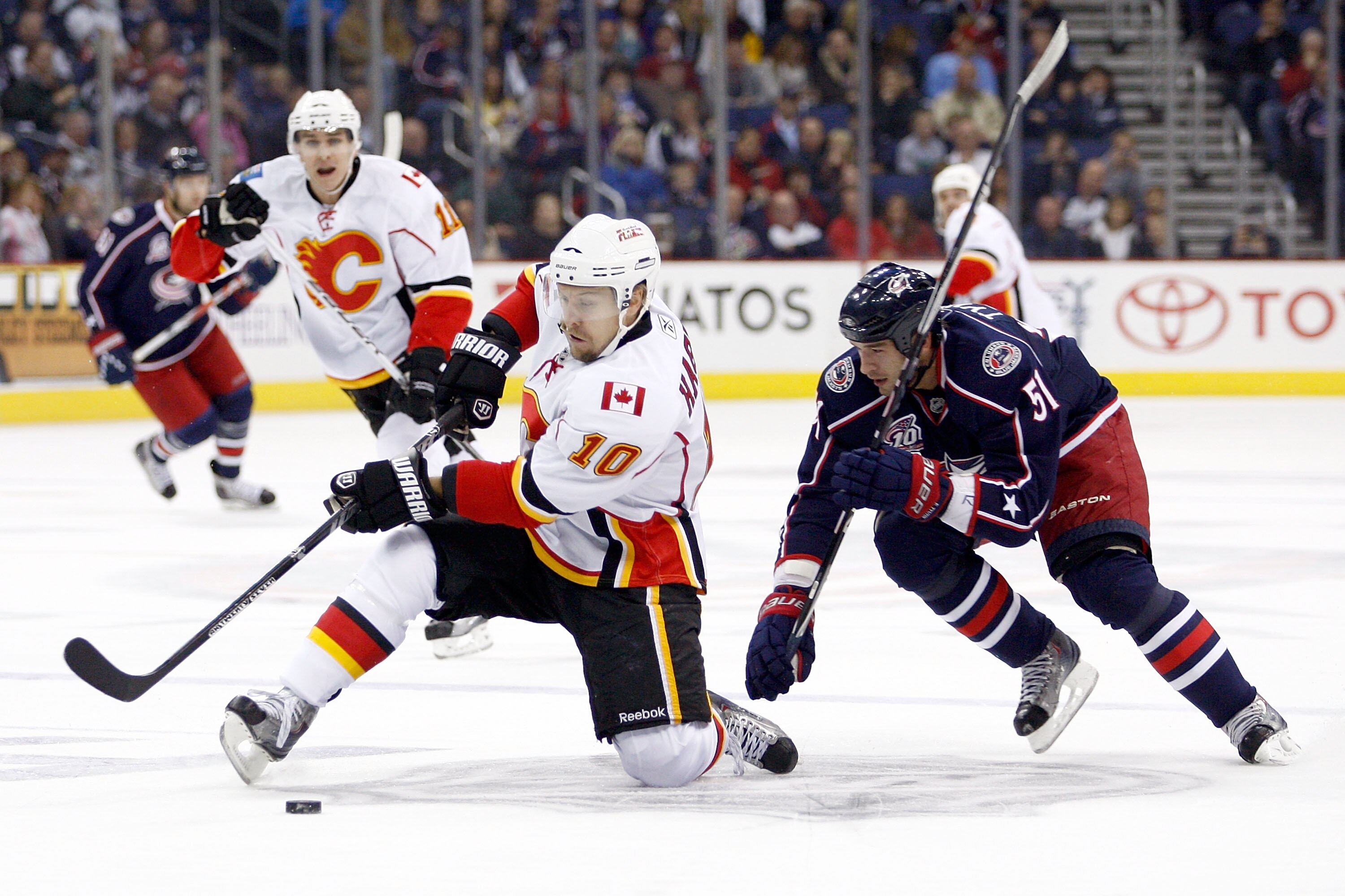 COLUMBUS, OH - OCTOBER 22:  Niklas Hagman #10 of the Calgary Flames looses his footing while trying to protect the puck from Fedor Tyutin #51 of the Columbus Blue Jackets during the first period on October 22, 2010 at Nationwide Arena in Columbus, Ohio.