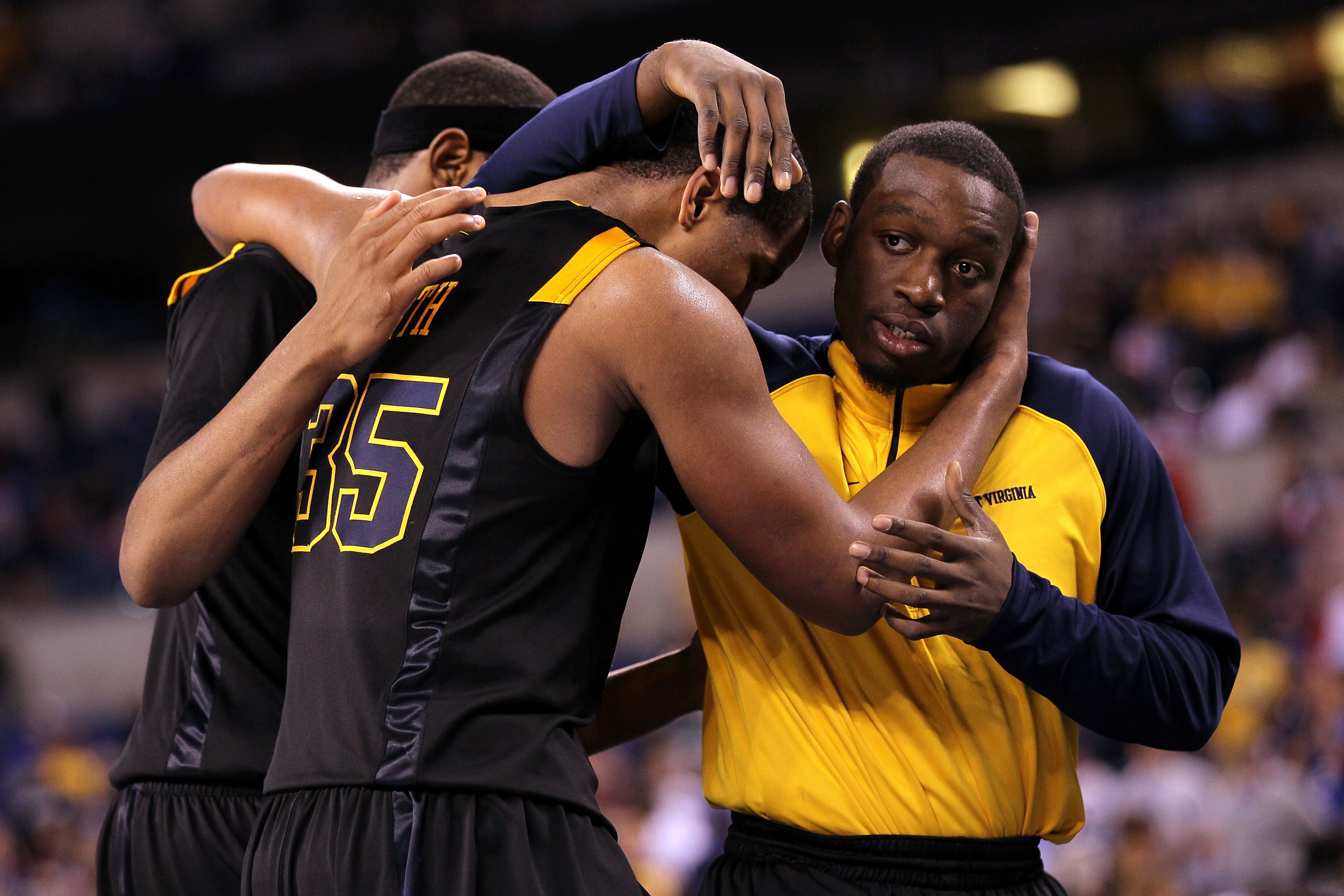 INDIANAPOLIS - APRIL 03:  (L-R) Kevin Jones #5, Wellington Smith #35 and injured guard Darryl Bryant of the West Virginia Mountaineers console each other after they lost 78-57 against the Duke Blue Devils during the National Semifinal game of the 2010 NCA