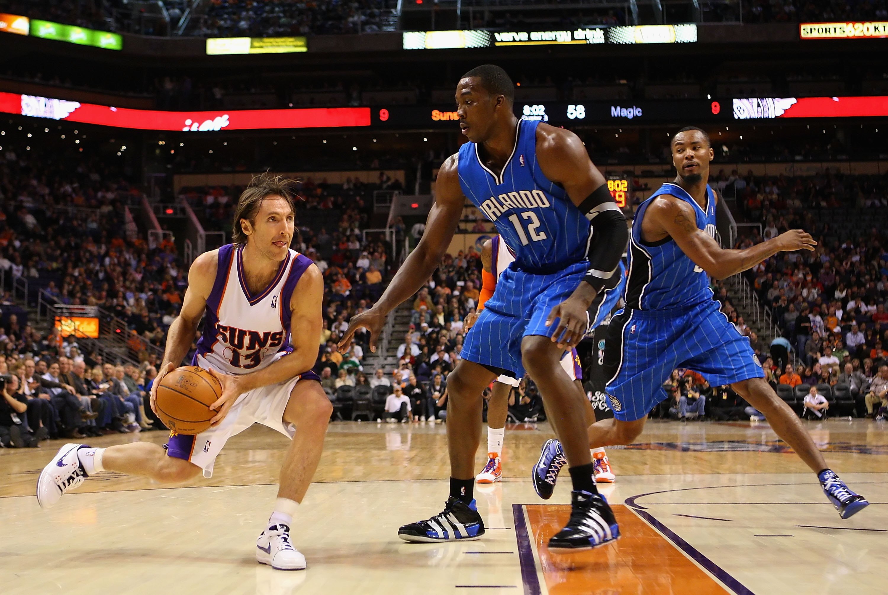 PHOENIX - DECEMBER 11:  Steve Nash #13 of the Phoenix Suns handles the ball under pessure from Dwight Howard #12 of the Orlando Magic during the NBA game at US Airways Center on December 11, 2009 in Phoenix, Arizona. The Suns defeated the Magic 106-103.