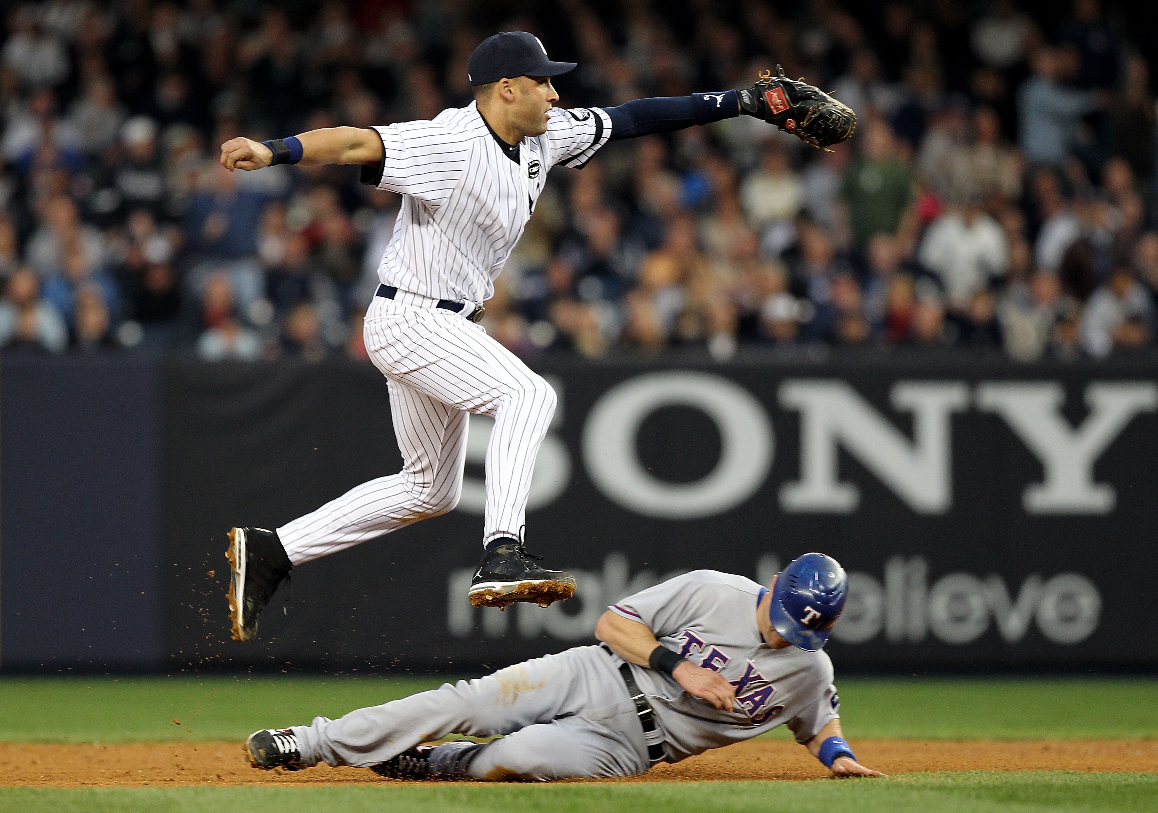 NEW YORK - OCTOBER 20:  Derek Jeter #2 of the New York Yankees turns a successful double play over a sliding Michael Young #10 of the Texas Rangers on a ball hit by Josh Hamilton #32 in the top of the fifth inning of Game Five of the ALCS during the 2010