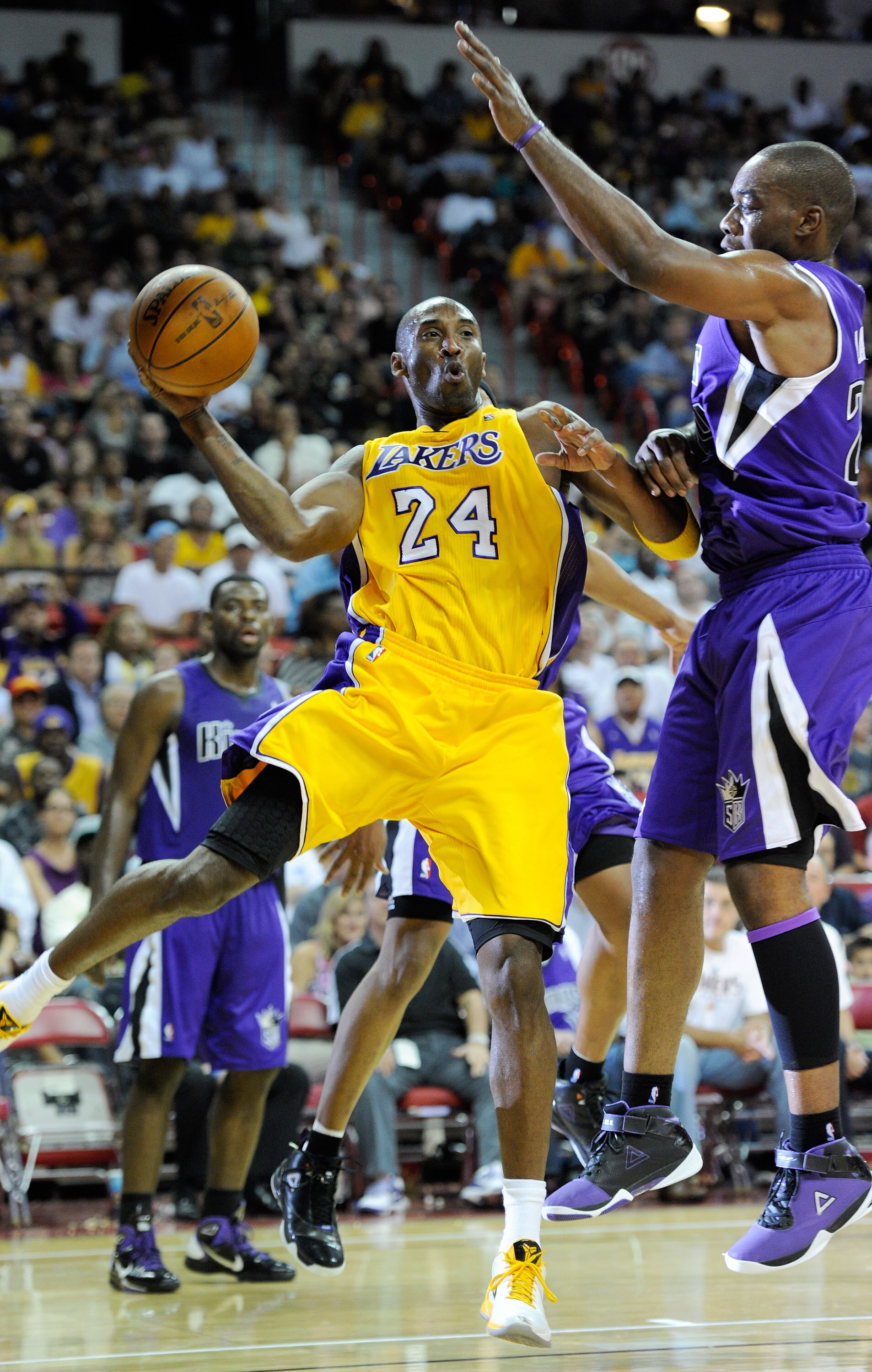 LAS VEGAS - OCTOBER 13:  Kobe Bryant #24 of the Los Angeles Lakers passes around Carl Landry #24 of the Sacramento Kings during their preseason game at the Thomas & Mack Center October 13, 2010 in Las Vegas, Nevada. The Lakers won 98-95. NOTE TO USER: Use