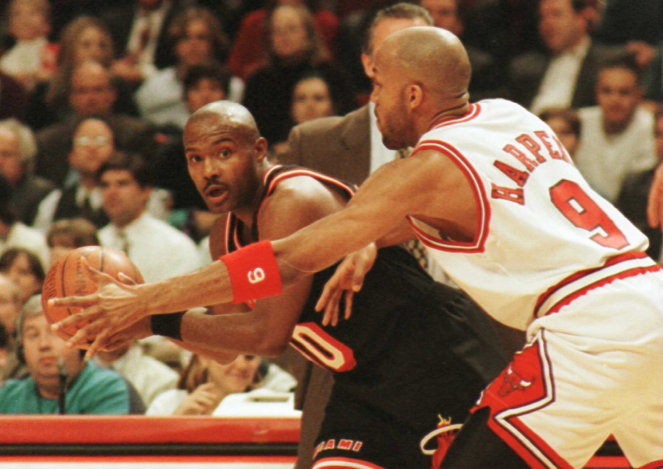 4  Apr 1996:  Guard Tim Hardaway of the Miami Heat looks for an open teammate around the reaching arm of guard Ron Harper of the Chicago Bulls during first quarter action of their game at the United Center in Chicago, Illinois.     Mandatory Credit: Jonat
