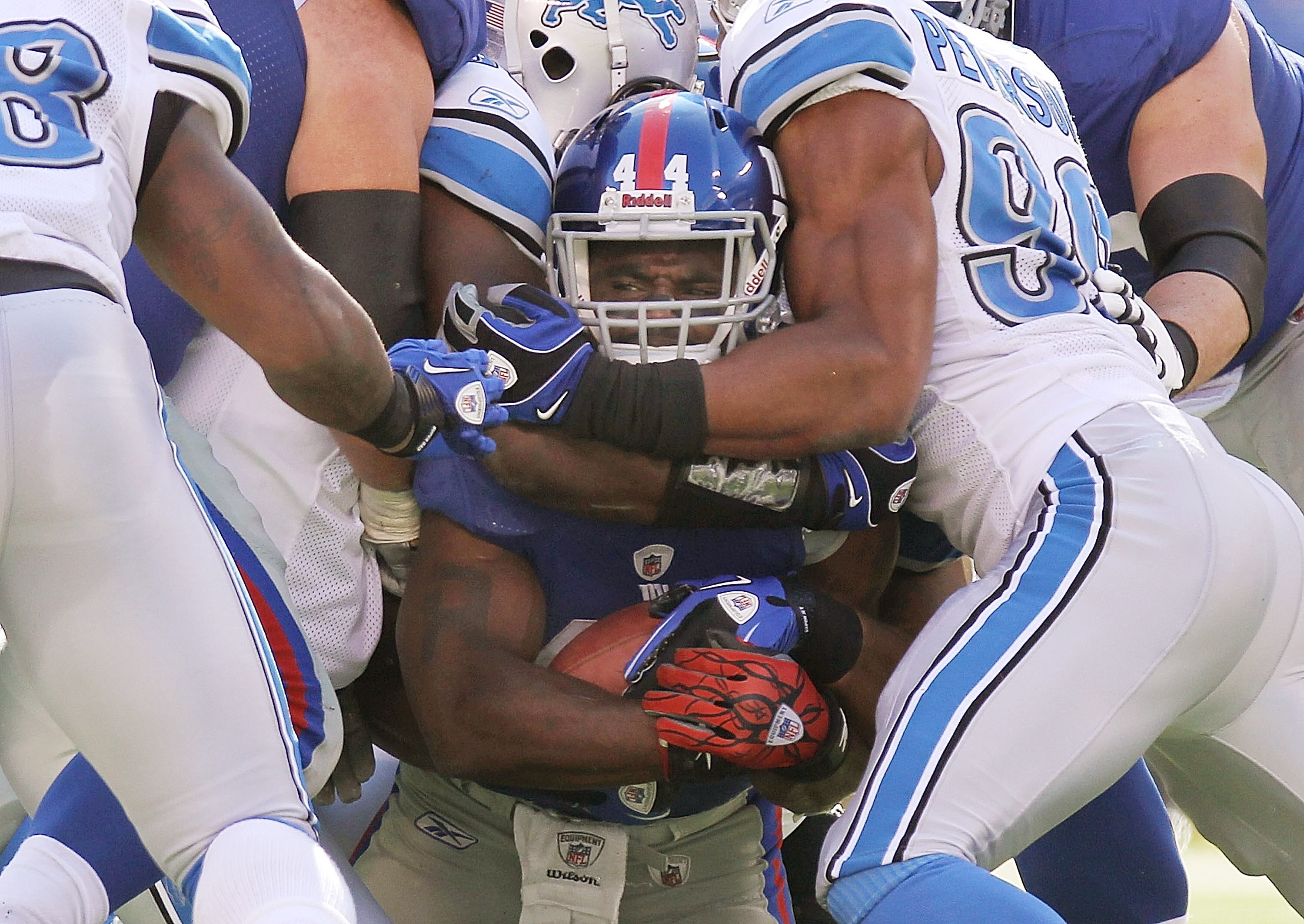 EAST RUTHERFORD, NJ - OCTOBER 17: Ahmad Bradshaw #44 of the New York Giants is tackled by Julian Peterson #98 of the Detroit Lions at New Meadowlands Stadium on October 17, 2010 in East Rutherford, New Jersey.  (Photo by Nick Laham/Getty Images)