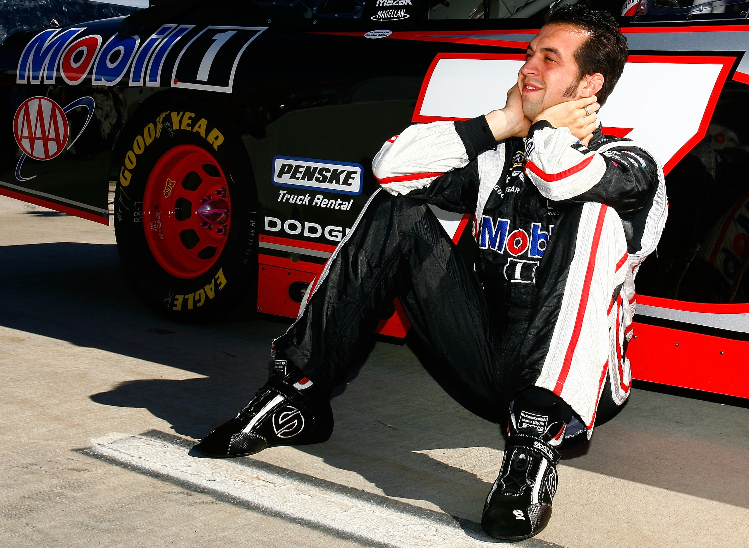 MARTINSVILLE, VA - OCTOBER 24:  Sam Hornish Jr., driver of the #77 Mobil 1 Dodge, sits next to his car on the grid prior to the NASCAR Sprint Cup Series TUMS Fast Relief 500 at Martinsville Speedway on October 24, 2010 in Martinsville, Virginia.  (Photo b