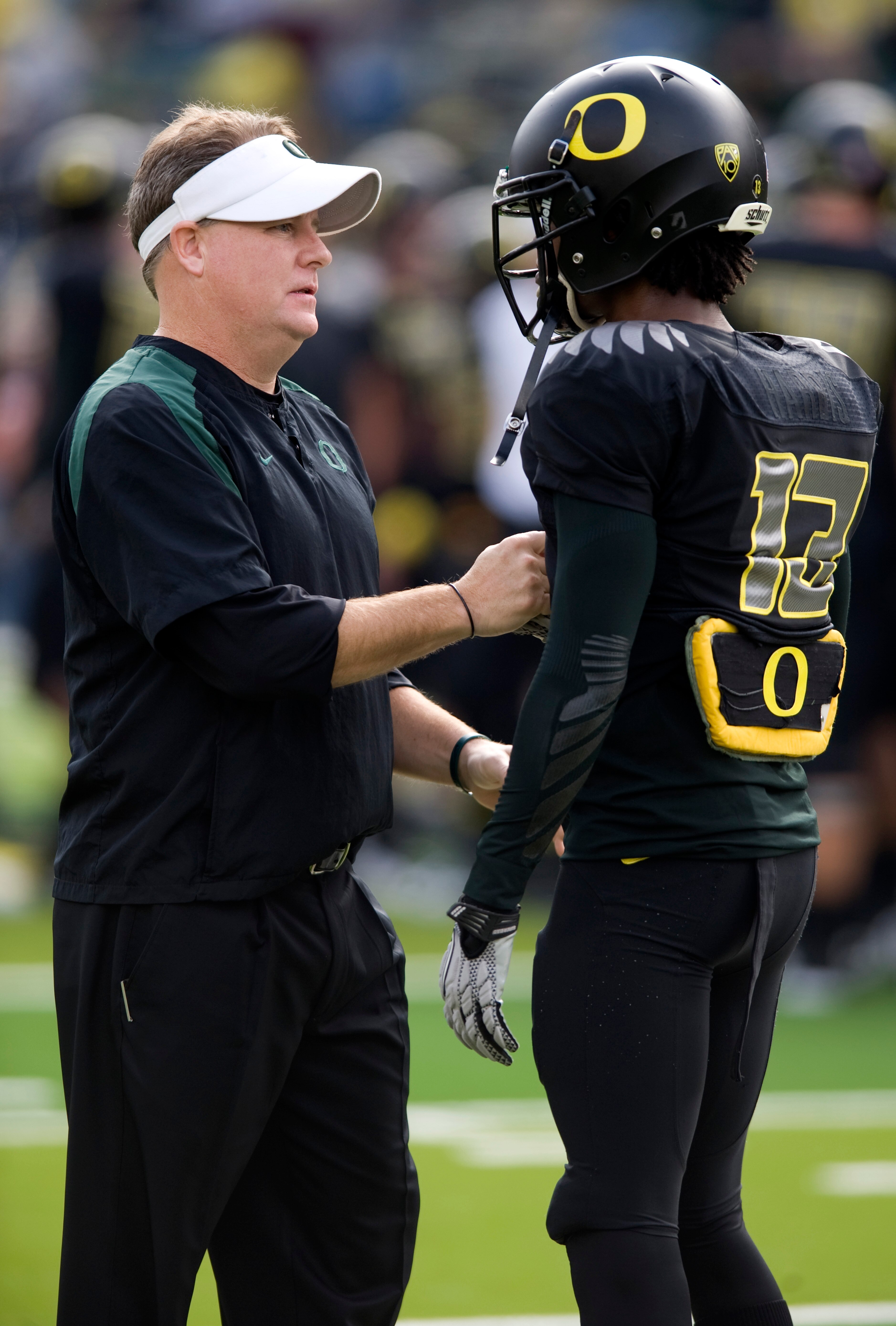 EUGENE, OR - NOVEMBER 6: Head coach Chip Kelly speaks with cornerback Cliff Harris #13 of the Oregon Ducks before the game against the Washington Huskies at Autzen Stadium on November 6, 2010 in Eugene, Oregon. (Photo by Steve Dykes/Getty Images)