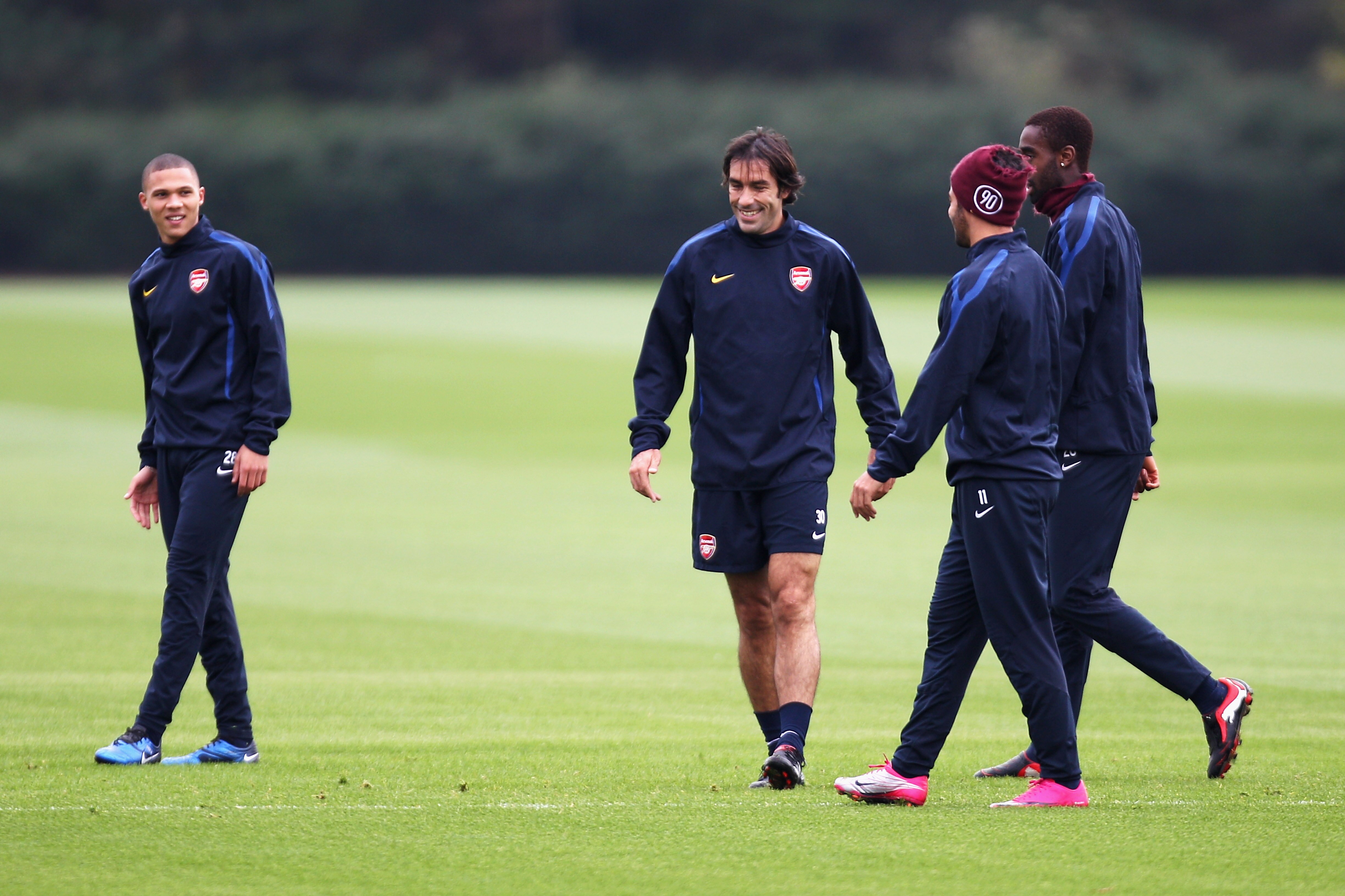 ST ALBANS, ENGLAND - OCTOBER 18:  Former Arsenal player Robert Pires (C) shares a joke with players during a training session ahead of the UEFA Champions League game against Shakhtar Donetsk at the club's complex at London Colney on October 18, 2010 in St
