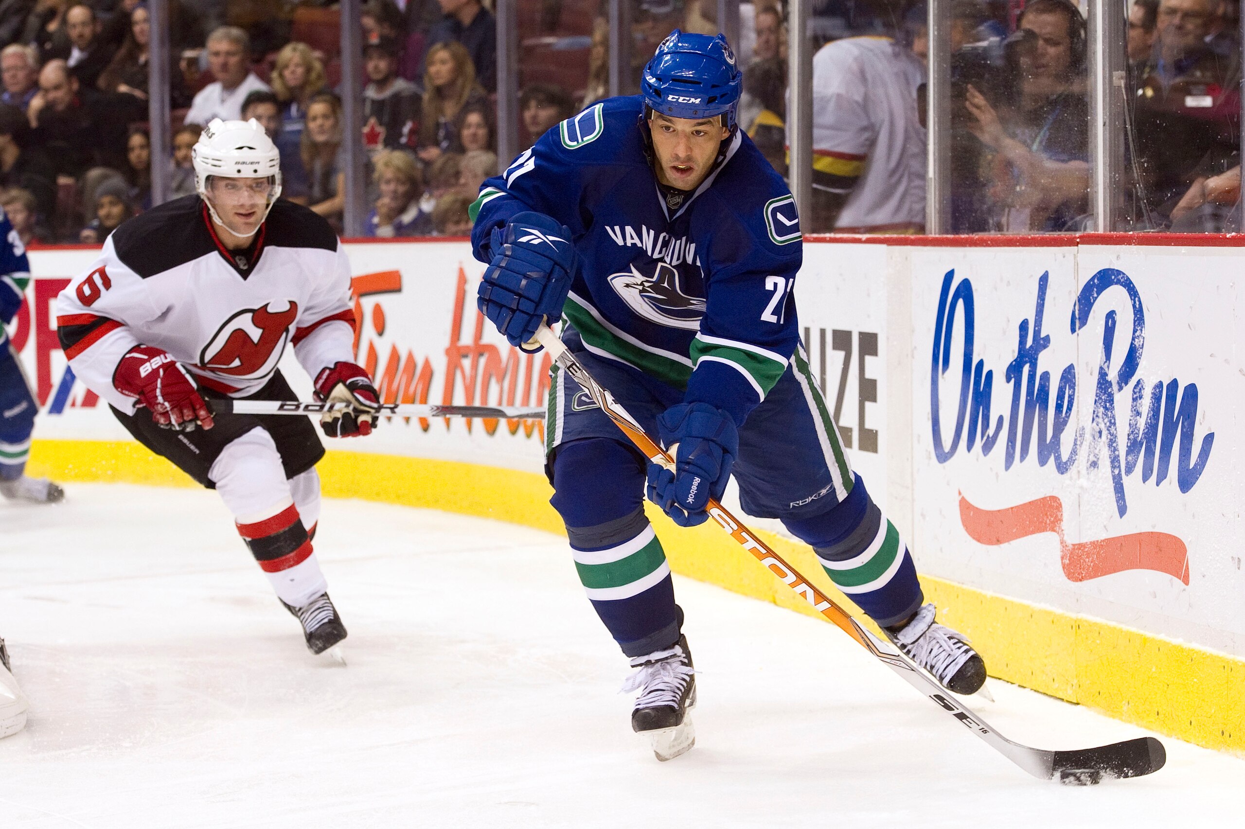 VANCOUVER, CANADA - NOVEMBER 1: Manny Malhotra #27 of the Vancouver Canucks makes a pass after getting past Andy Greene #6 of the New Jersey Devils during the second period in NHL action on November 01, 2010 at Rogers Arena in Vancouver, British Columbia, VANCOUVER, CANADA - NOVEMBER 1: Manny Malhotra #27 of the Vancouver Canucks makes a pass after getting past Andy Greene #6 of the New Jersey Devils during the second period in NHL action on November 01, 2010 at Rogers Arena in Vancouver, British Columbia,