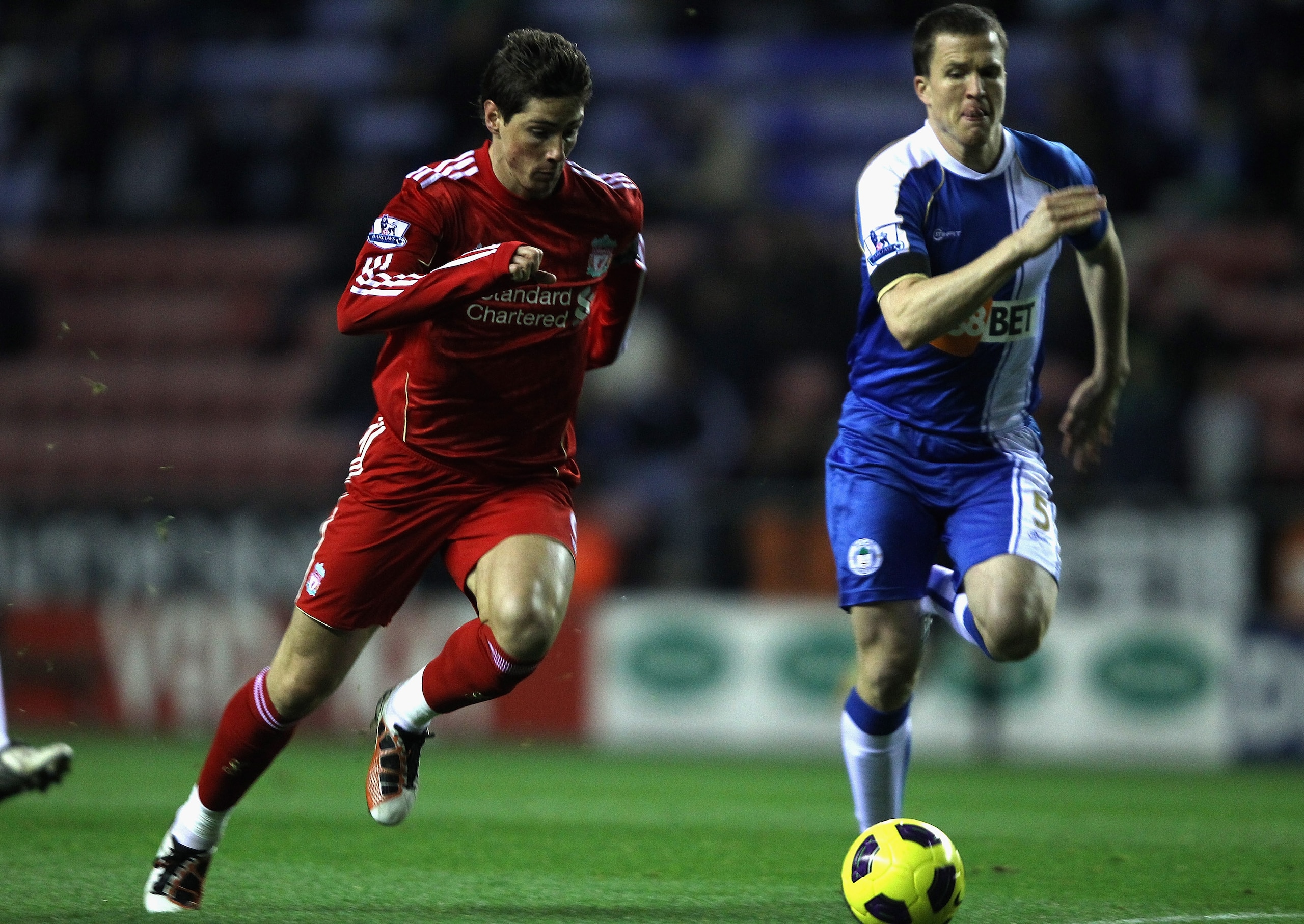 WIGAN, ENGLAND - NOVEMBER 10:  Fernando Torres  of Liverpool breaks away from Gary Caldwell of Wigan to score the first goal during the Barclays Premier League match between Wigan Athletic and Liverpool at DW Stadium on November 10, 2010 in Wigan, England