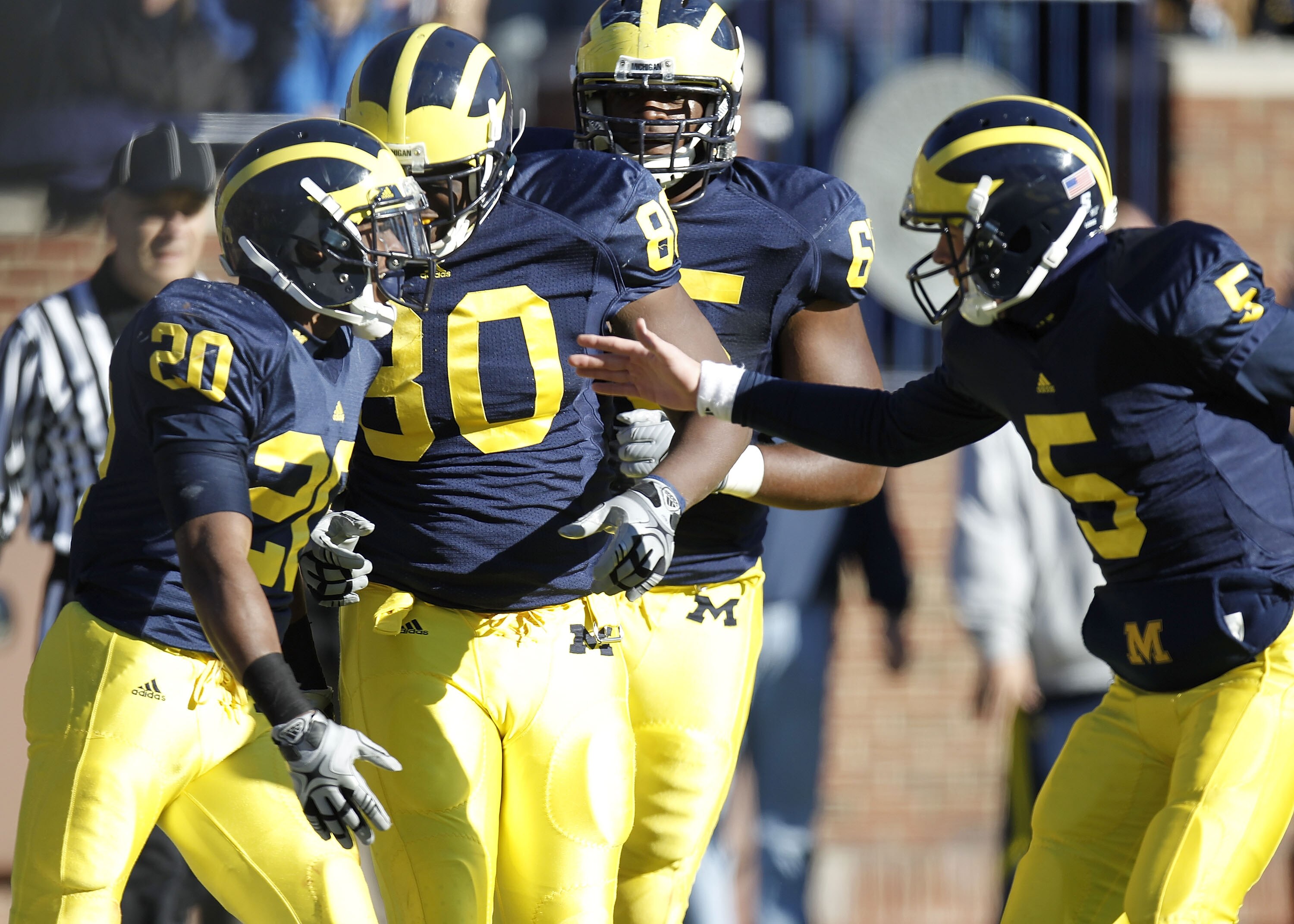 ANN ARBOR, MI - NOVEMBER 06:  Michael Shaw #20 of the Michigan Wolverines celebrates an overtime touchdown with Tate Forcier #5 and Martell Webb #80 while playing the Illinios Fighting Illini at Michigan Stadium on November 6, 2010 in Ann Arbor, Michigan.