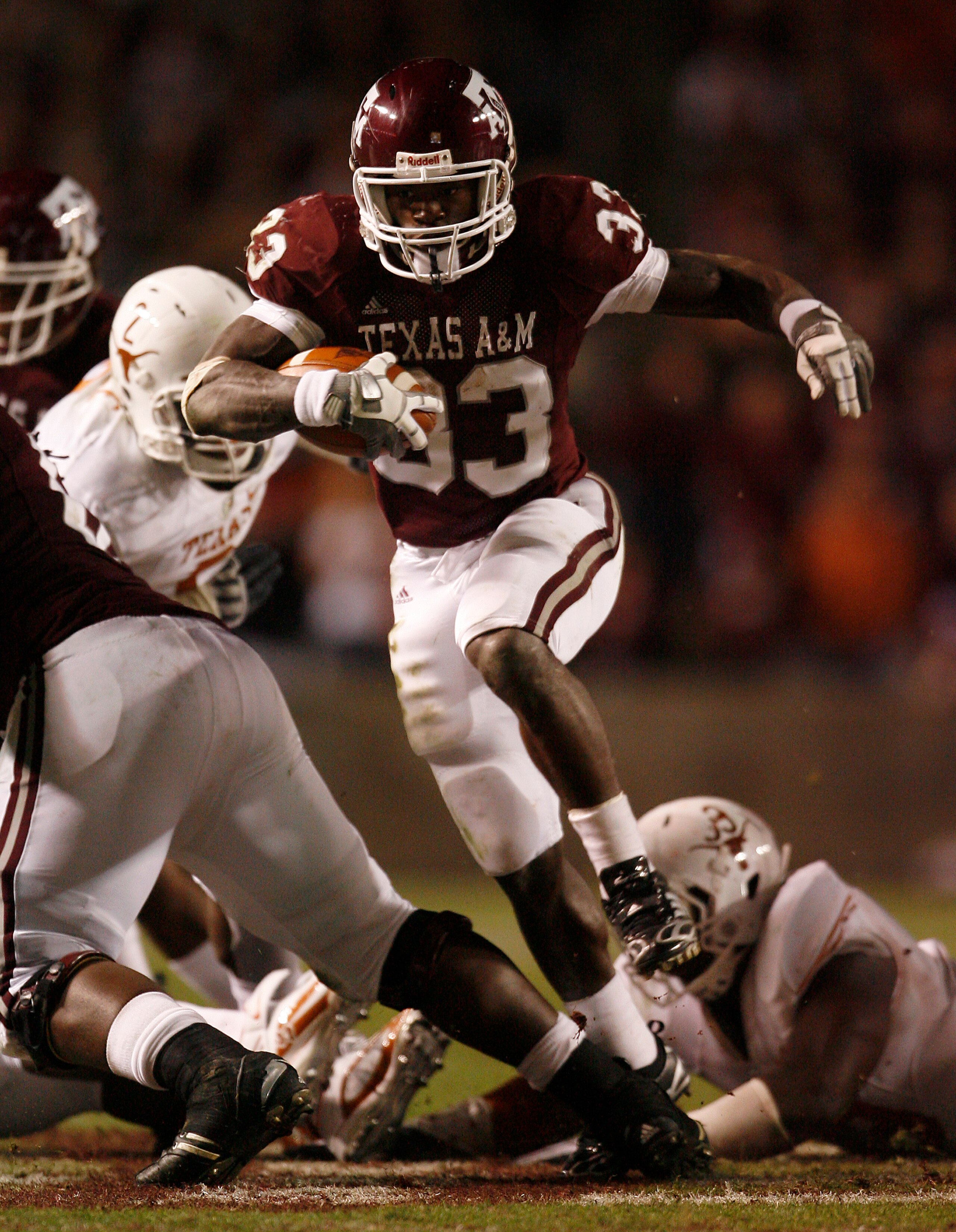 COLLEGE STATION, TX - NOVEMBER 26: Tailback Christine Michael #33 of the Texas A&M Aggies rushes for a gain against the Texas Longhorns defense in the second half at Kyle Field on November 26, 2009 in College Station, Texas. The Longhorns defeated the Agg