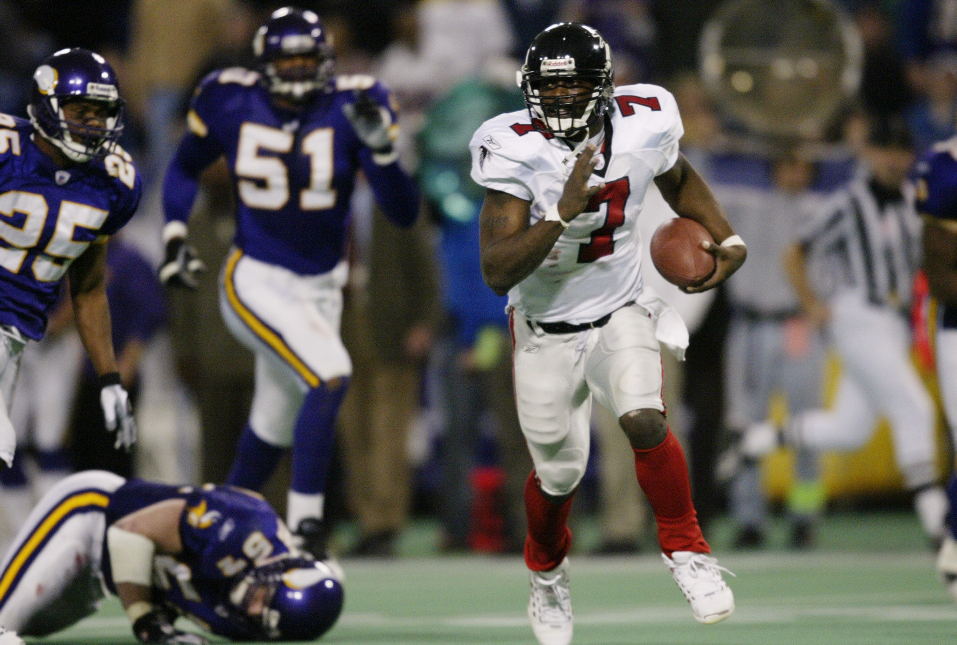MINNEAPOLIS - DECEMBER 1:  Quarterback Michael Vick #7 of the Atlanta Falcons scrambles with the ball during the NFL game against the Minnesota Vikings on December 1, 2002 at the Hubert H. Humphrey Metrodome in Minneapolis, Minnesota. The Falcons beat the