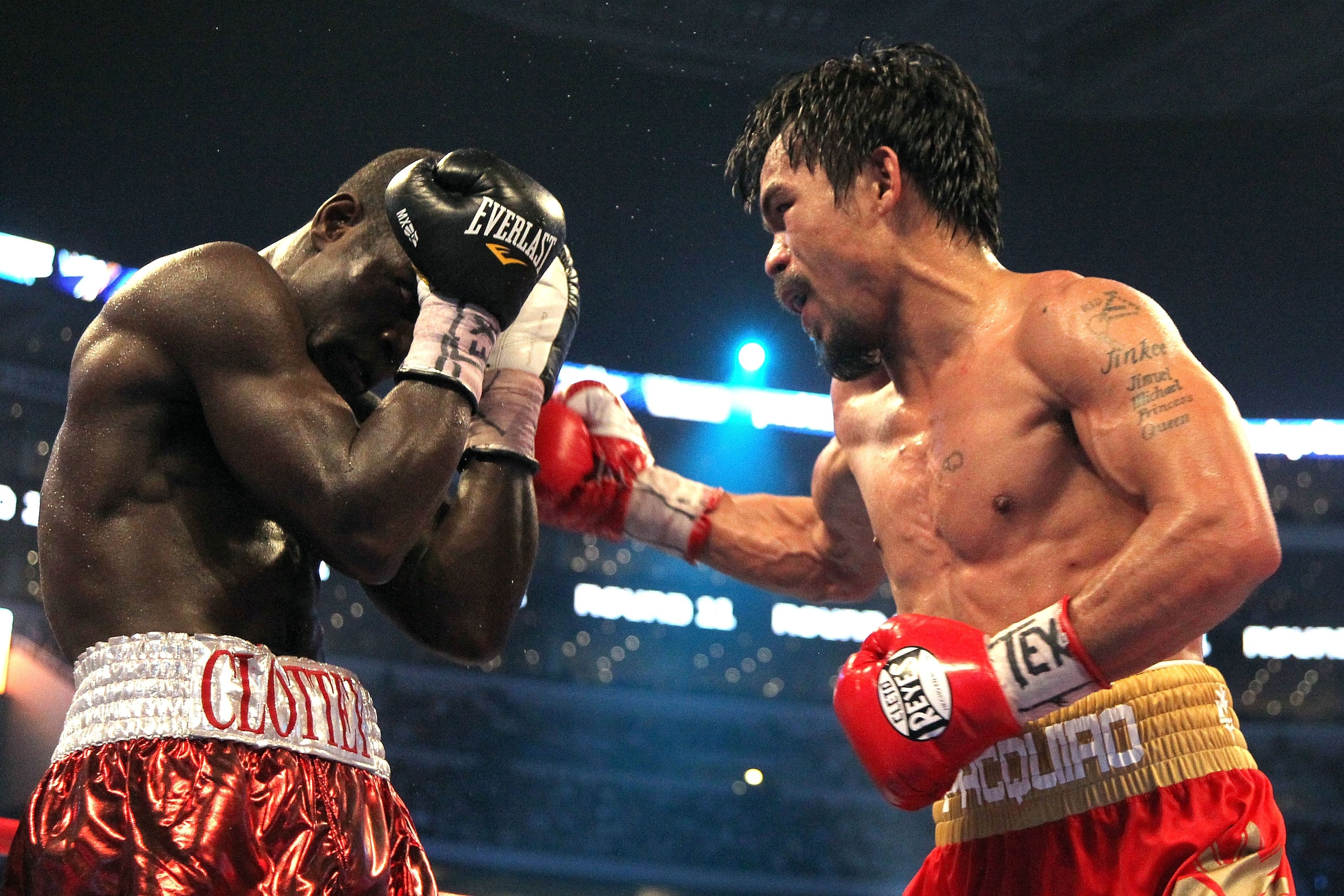 ARLINGTON, TX - MARCH 13:  (R-L) Manny Pacquiao of the Philippines throws a right to the body of Joshua Clottey of Ghana during the WBO welterweight title fight at Cowboys Stadium on March 13, 2010 in Arlington, Texas. Pacquiao defeated Clottey by unanimo