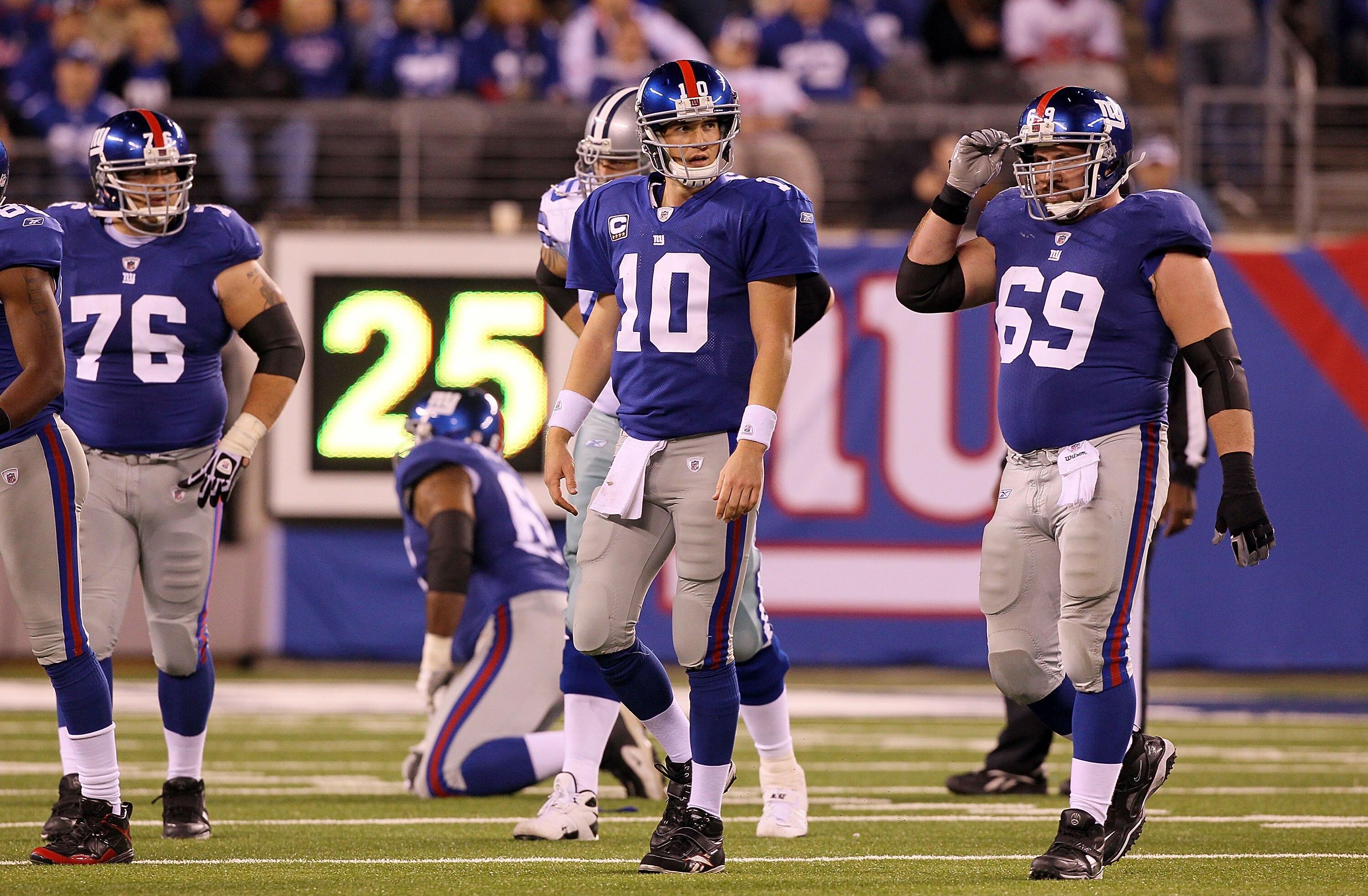 EAST RUTHERFORD, NJ - NOVEMBER 14:  Chris Snee #76, Eli Manning #10, and Rich Seubert #69 of the New York Giants walk off the field after losing the ball on a fumble in the fourth quarter against of the Dallas Cowboys on November 14, 2010 at the New Meado