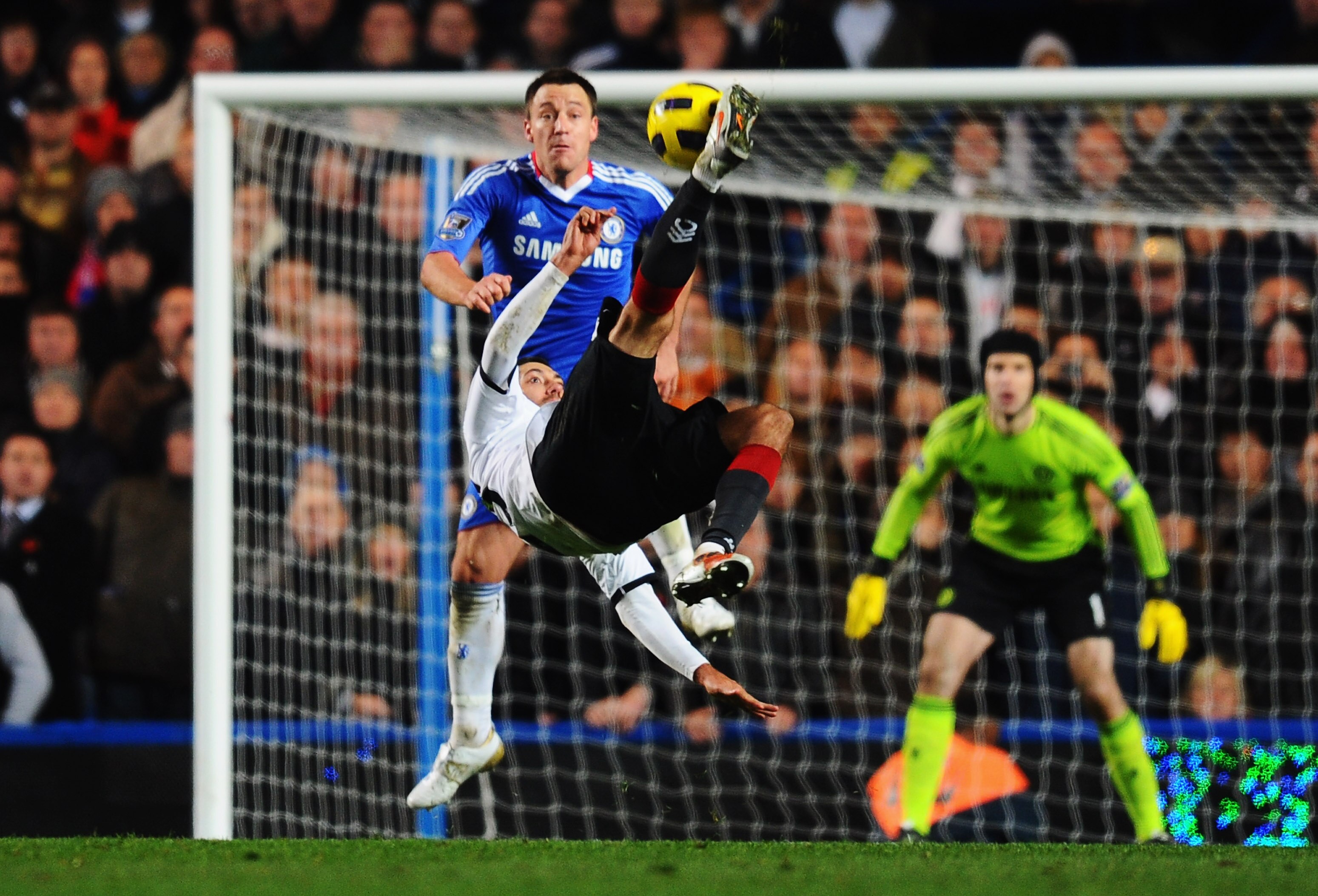 LONDON, ENGLAND - NOVEMBER 10:  John Terry of Chelsea attempts to stop Clint Dempsey of Fulham shooting with an overhead kick during the Barclays Premier League match between Chelsea and Fulham at Stamford Bridge on November 10, 2010 in London, England.  