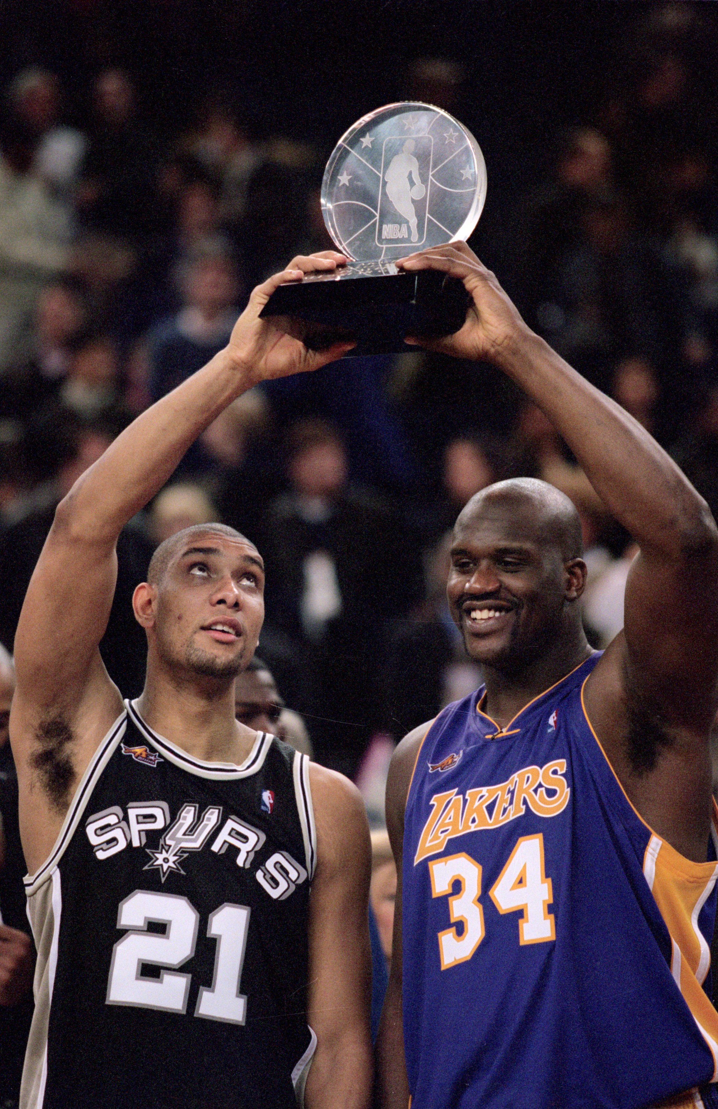 12 Feb 2000: Shaquille O''Neal #34 of the Los Angeles Lakers holds up the winning trophy with Tim Duncan #21 of the San Antonio Spurs after the NBA Allstar Game at the Oakland Coliseum in Oakland, California. The West defeated the East 137-126    Mandator