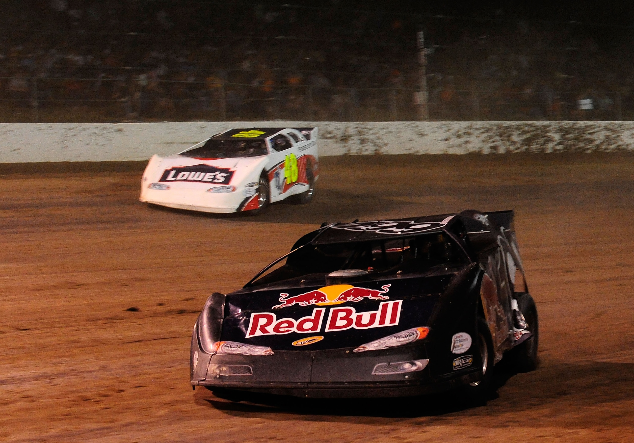 ROSSBURG, OH - JUNE 09:  Travis Pastrana, driver of the #199 Red Bull late model Subaru, leads Jimmie Johnson, driver of the #48 Lowes late model Chevrolet, through turn three during the Gillette Fusion ProGlide Prelude to the Dream at Eldora Speedway on