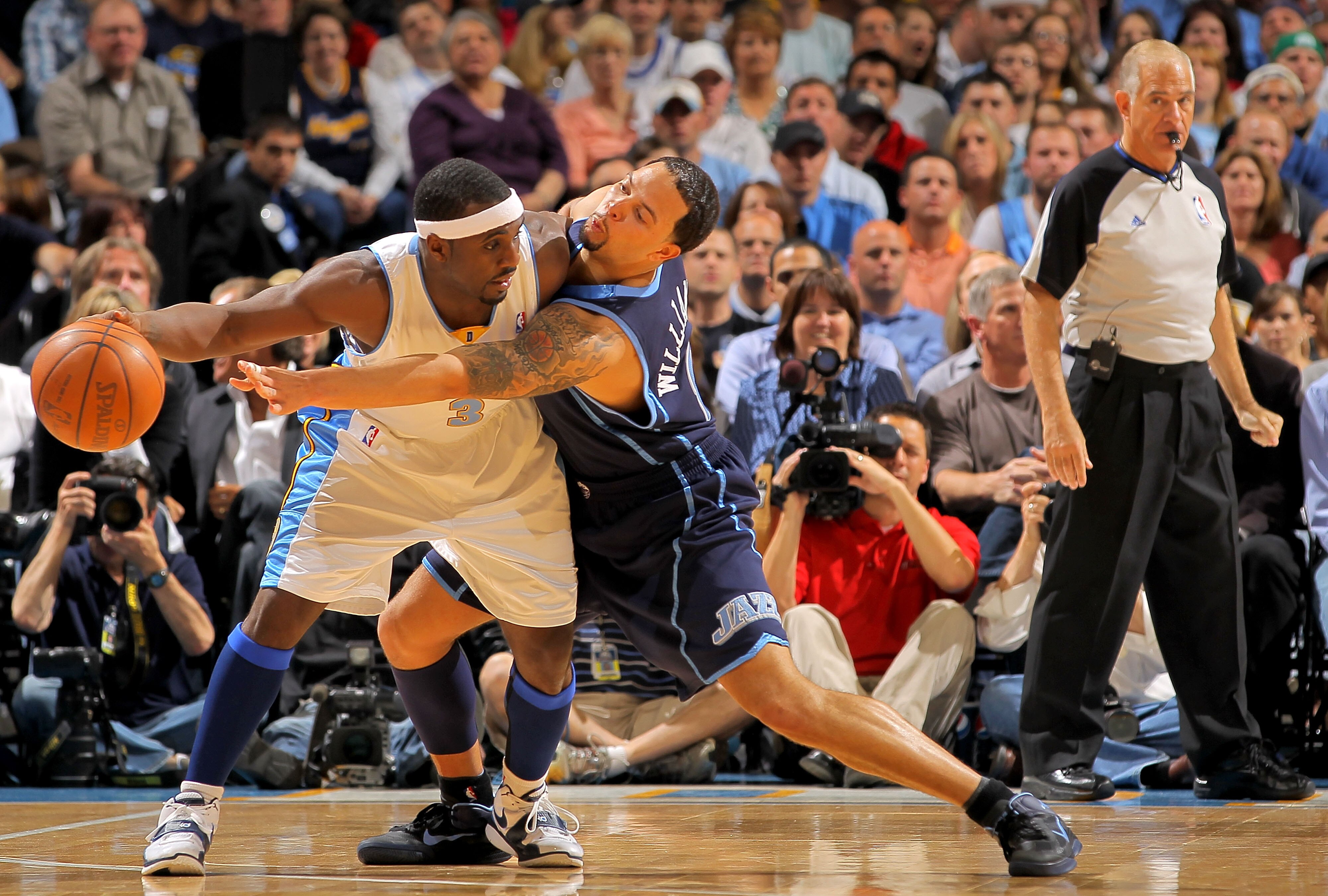 DENVER - APRIL 28:  Ty Lawson #3 of the Denver Nuggets controls the ball as Deron Williams #8 of the Utah Jazz defends as referee Bennett Salvatore oversees the action in Game Five of the Western Conference Quarterfinals of the 2010 NBA Playoffs at the Pe