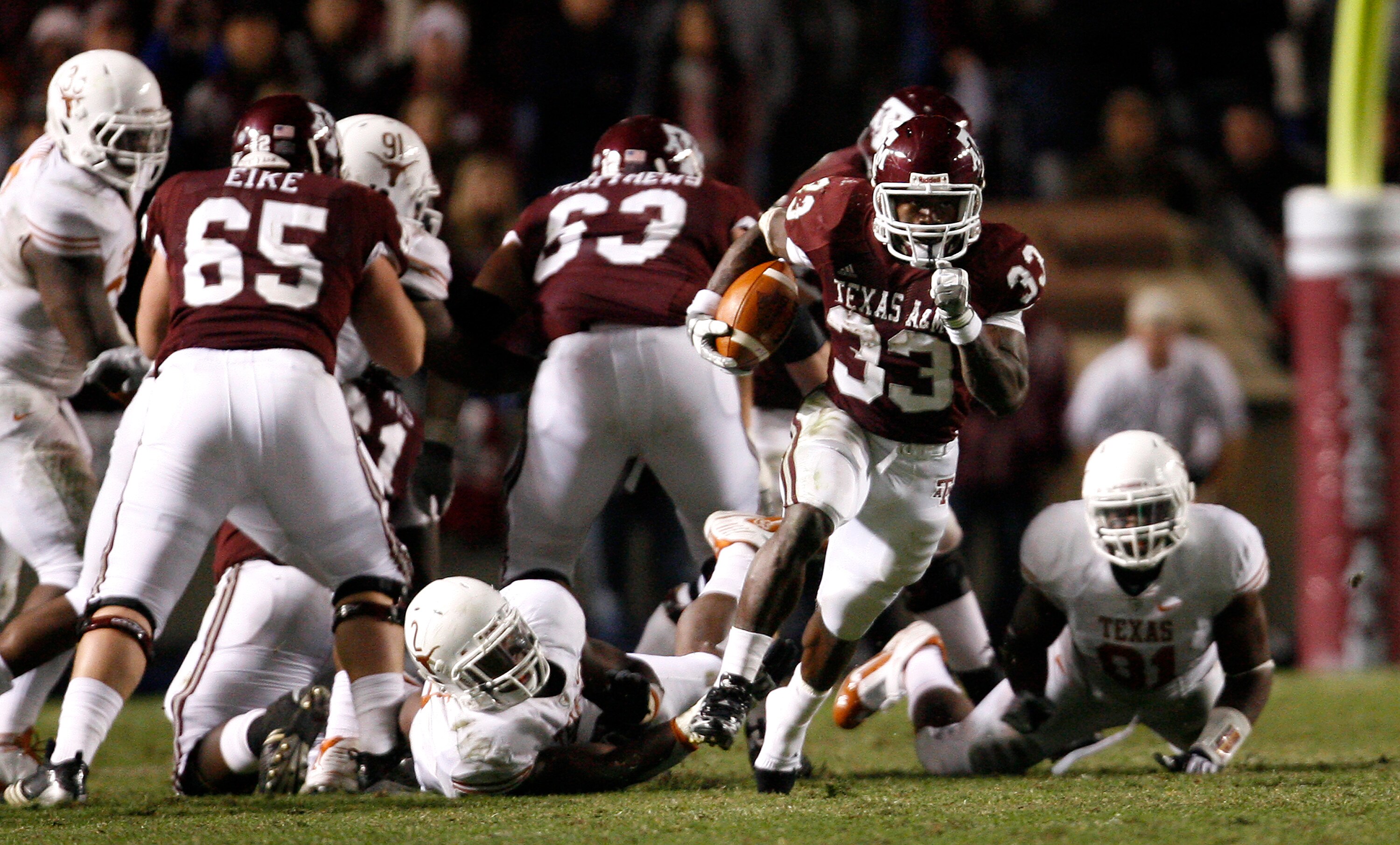 COLLEGE STATION, TX - NOVEMBER 26: Tailback Christine Michael #33 of the Texas A&M Aggies rushes for a gain against the Texas Longhorns defense in the second half at Kyle Field on November 26, 2009 in College Station, Texas. The Longhorns defeated the Agg