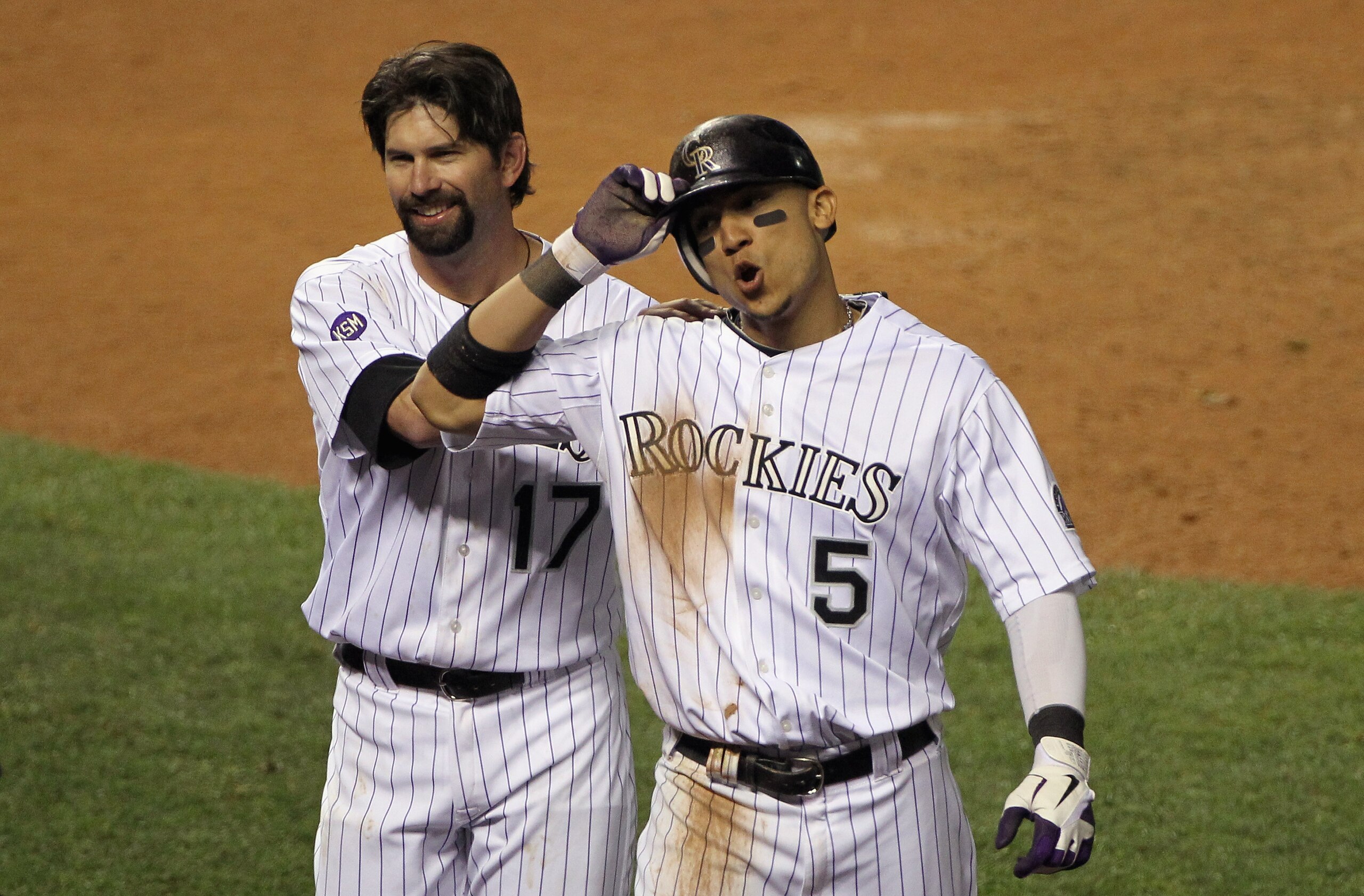 DENVER - SEPTEMBER 25: Carlos Gonzalez #5 of the Colorado Rockies breathes deep as he celebrates with Todd Helton #17 after Gonzalez scored the game winning against the San Francisco Giants on a double by Troy Tulowitzki in the 10th inning at Coors Field DENVER - SEPTEMBER 25: Carlos Gonzalez #5 of the Colorado Rockies breathes deep as he celebrates with Todd Helton #17 after Gonzalez scored the game winning against the San Francisco Giants on a double by Troy Tulowitzki in the 10th inning at Coors Field