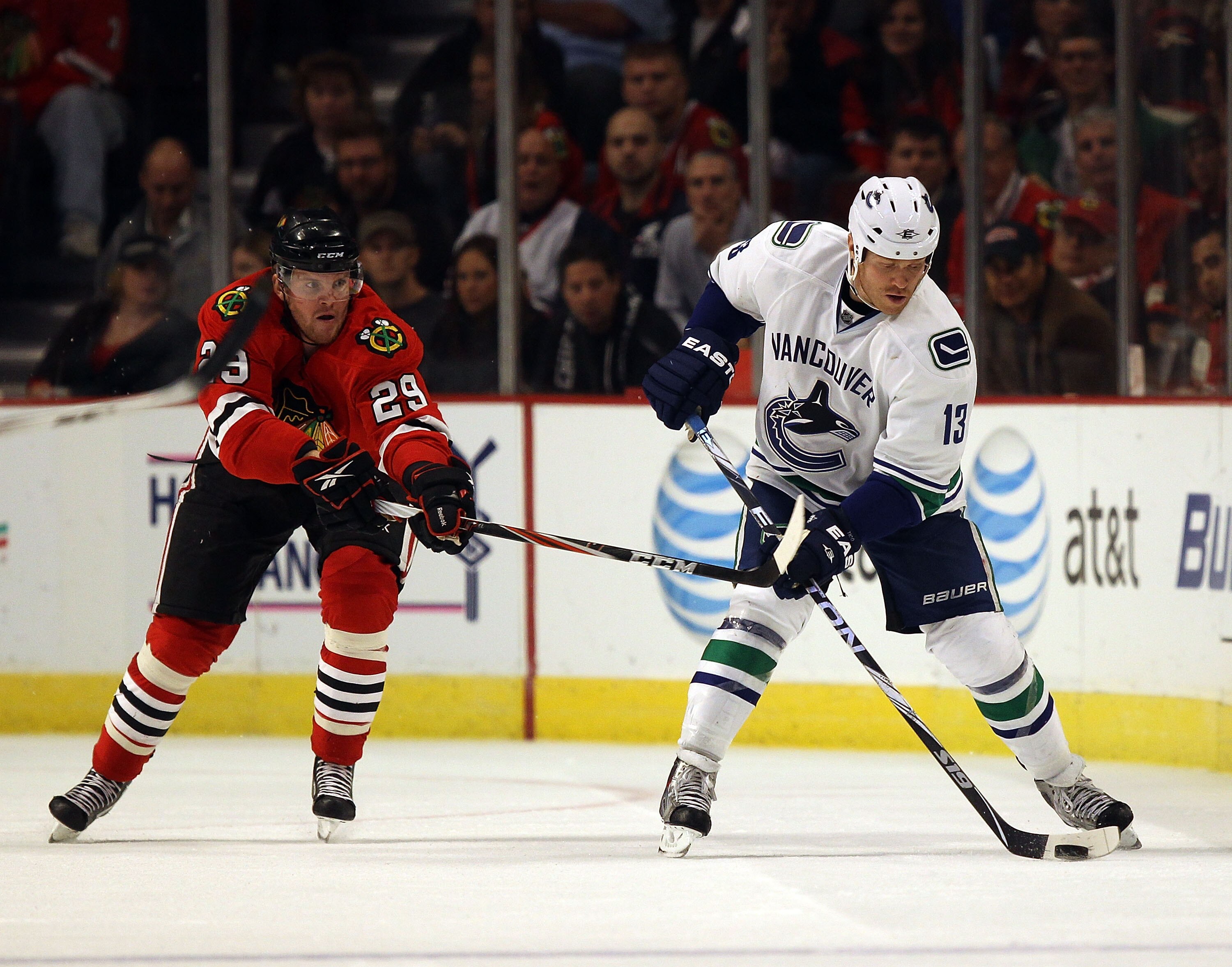 CHICAGO - OCTOBER 20: Raffi Torres #13 of the Vancouver Canucks controls the puck under pressure from Bryan Bickell #29 of the Chicago Blackhawks at the United Center on October 20, 2010 in Chicago, Illinois. The Blackhawks defeated the Canucks 2-1 in a s