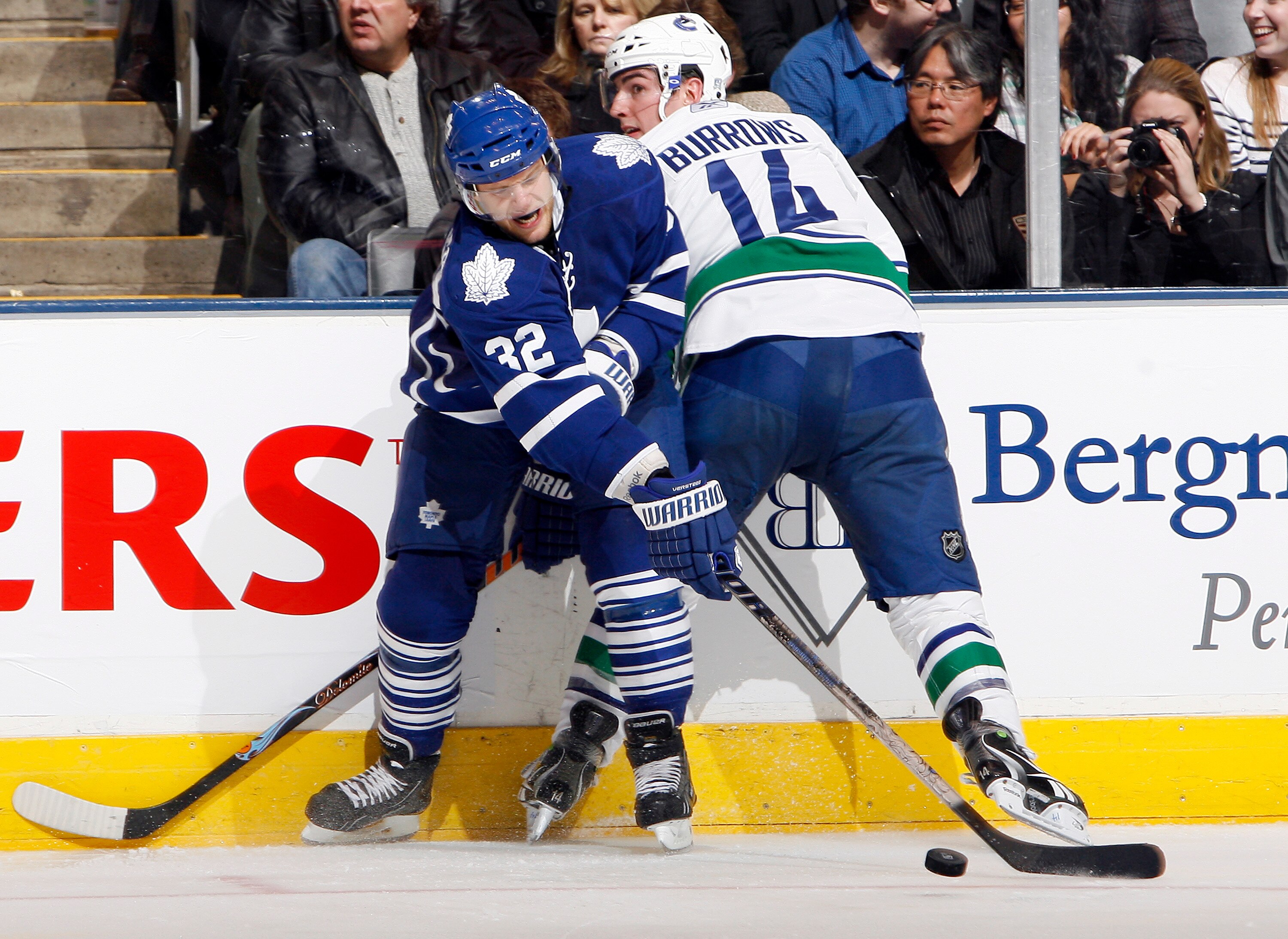 TORONTO - NOVEMBER 13: Kris Versteeg #32 of the Toronto Maple Leafs battles for the puck with Alex Burrows #14 of the Vancouver Canucks during game action at the Air Canada Centre November 13, 2010 in Toronto, Ontario, Canada. (Photo by Abelimages / Getty