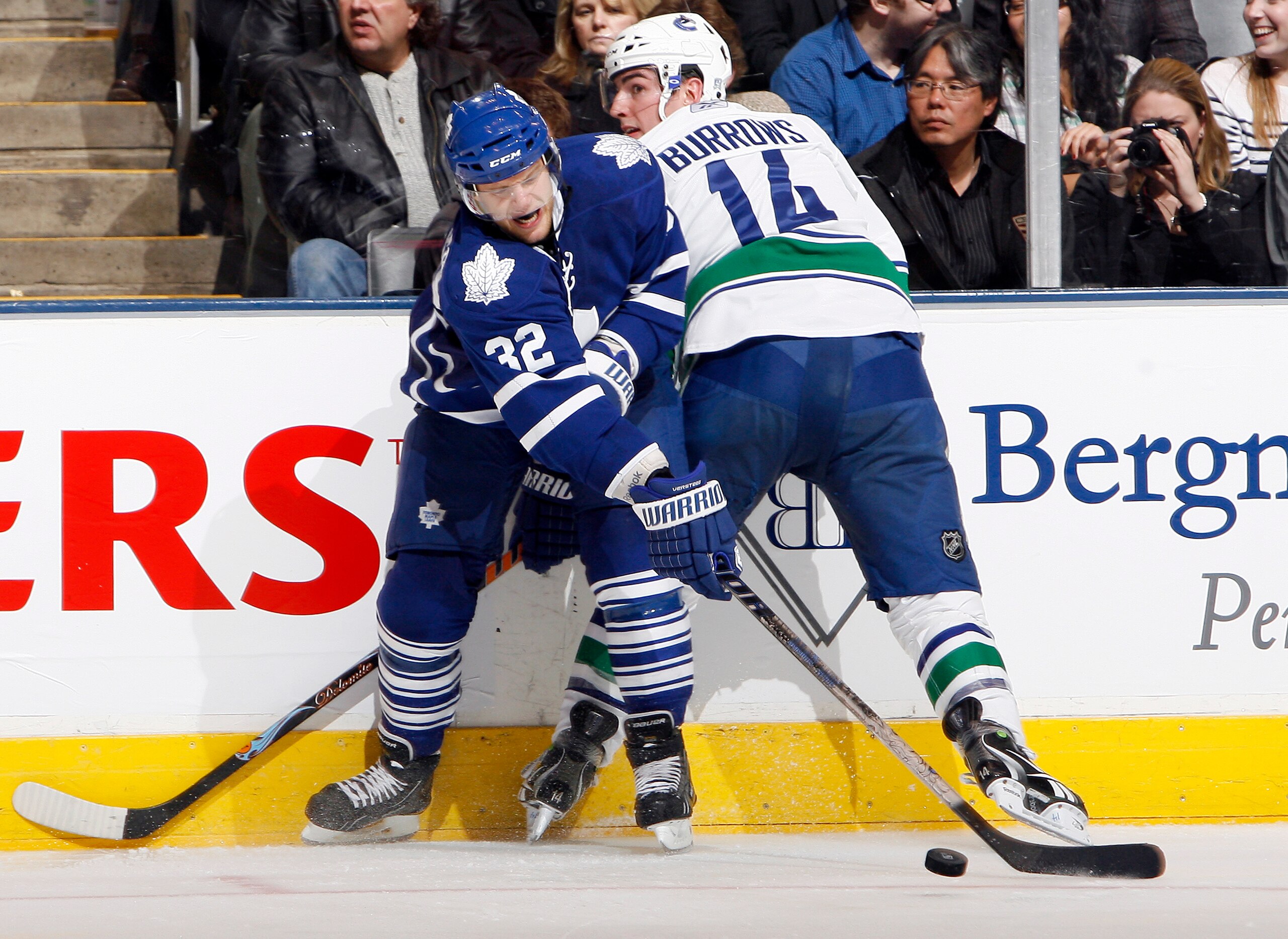 TORONTO - NOVEMBER 13: Kris Versteeg #32 of the Toronto Maple Leafs battles for the puck with Alex Burrows #14 of the Vancouver Canucks during game action at the Air Canada Centre November 13, 2010 in Toronto, Ontario, Canada. (Photo by Abelimages / Getty