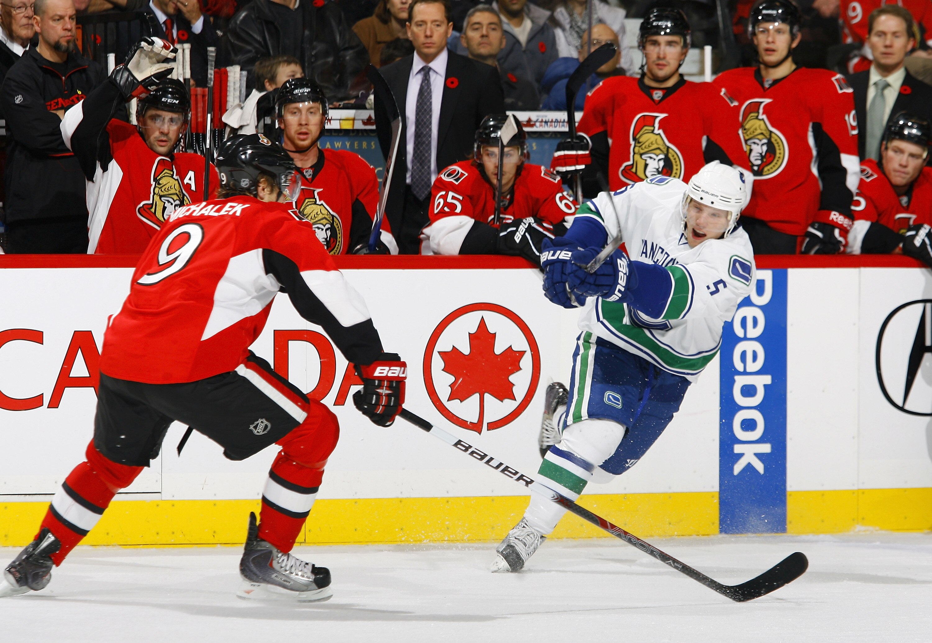 OTTAWA - NOVEMBER 11:  Christian Ehrhoff #5 of the Vancouver Canucks fires a slapshot from the point past defender Milan Michalek #9 of the Ottawa Senators in a game at Scotiabank Place on November 11, 2010 in Ottawa, Ontario, Canada.  (Photo by Phillip M