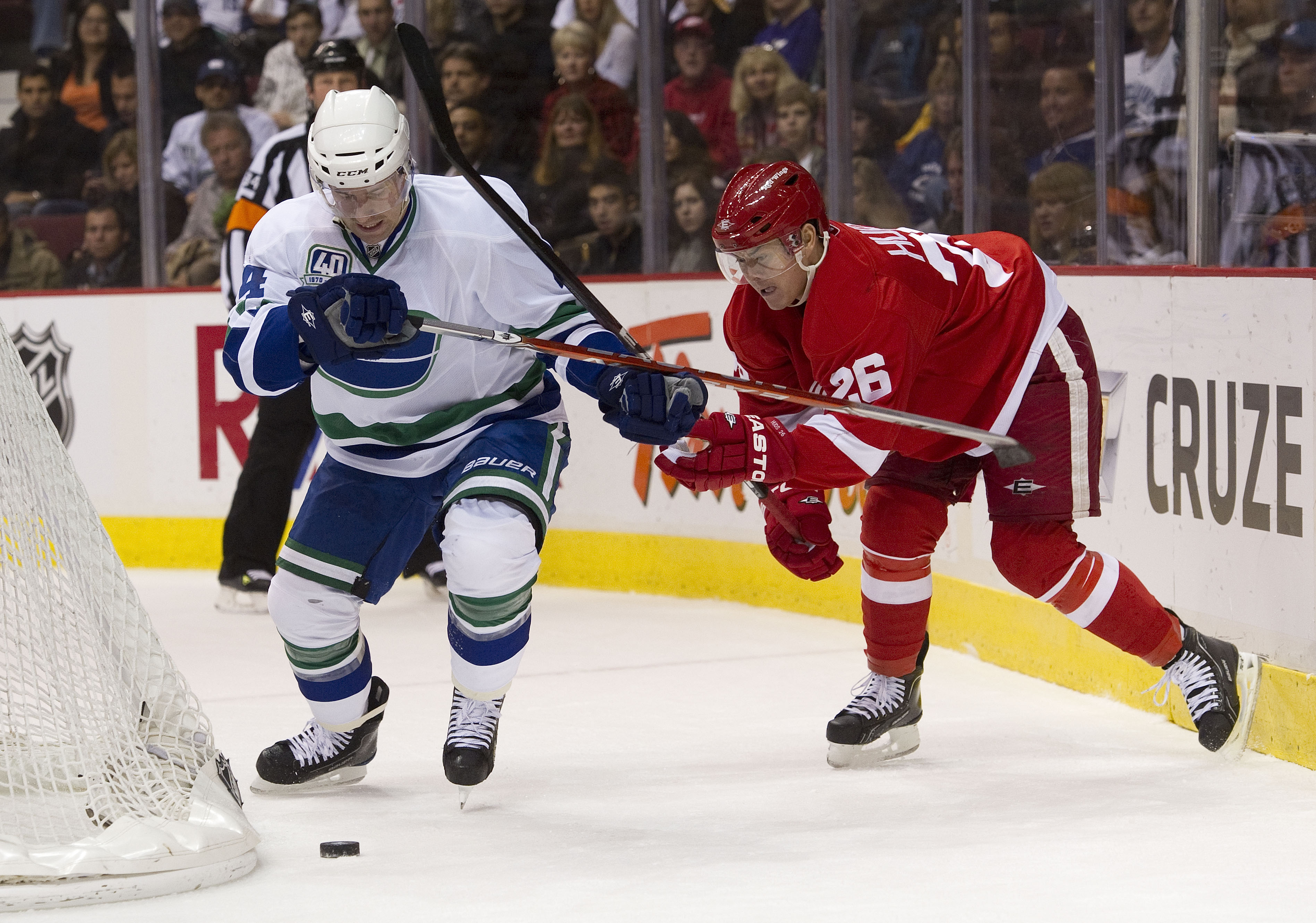 VANCOUVER, CANADA - NOVEMBER 6: Keith Ballard #4 of the Vancouver Canucks gets slashed by Jiri Hudler #26 of the Detroit Red Wings while battling for control of the loose puck during the first period in NHL action on November 06, 2010 at Rogers Arena in V
