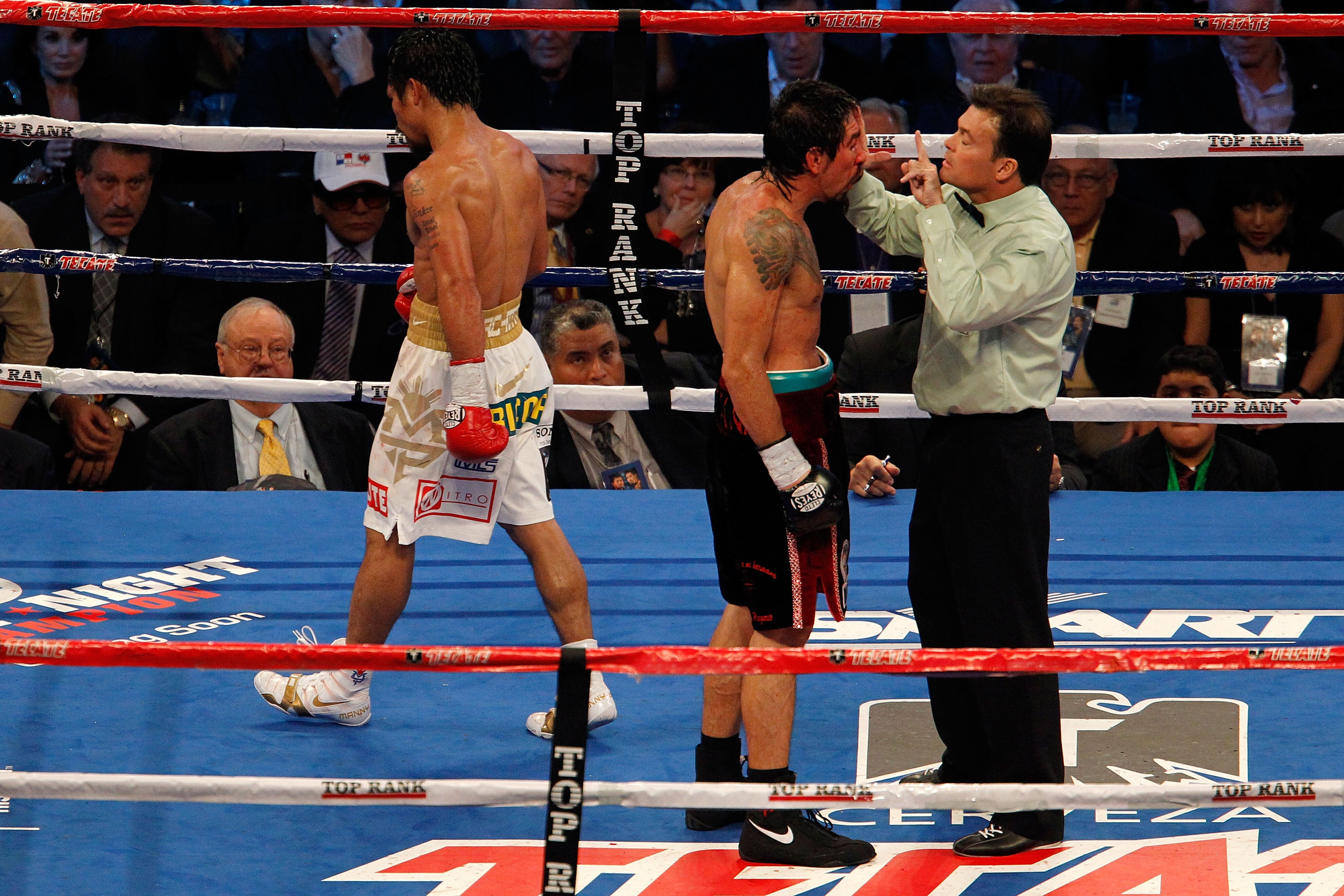 ARLINGTON, TX - NOVEMBER 13:  Referee Laurence Cole inspects the cut on the eye of Antonio Margarito (black trunks) of Mexico as Manny Pacquiao (white trunks) of the Philippines looks on during their WBC World Super Welterweight Title bout at Cowboys Stad