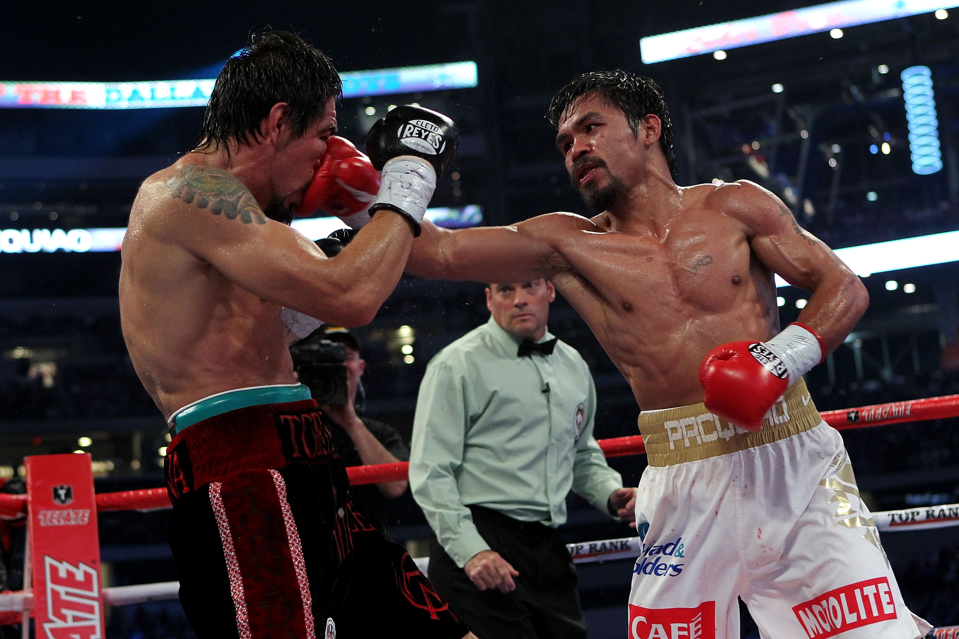 ARLINGTON, TX - NOVEMBER 13:  Manny Pacquiao (white trunks) of the Philippines lands a punch against Antonio Margarito (black trunks) of Mexico during their WBC World Super Welterweight Title bout at Cowboys Stadium on November 13, 2010 in Arlington, Texa