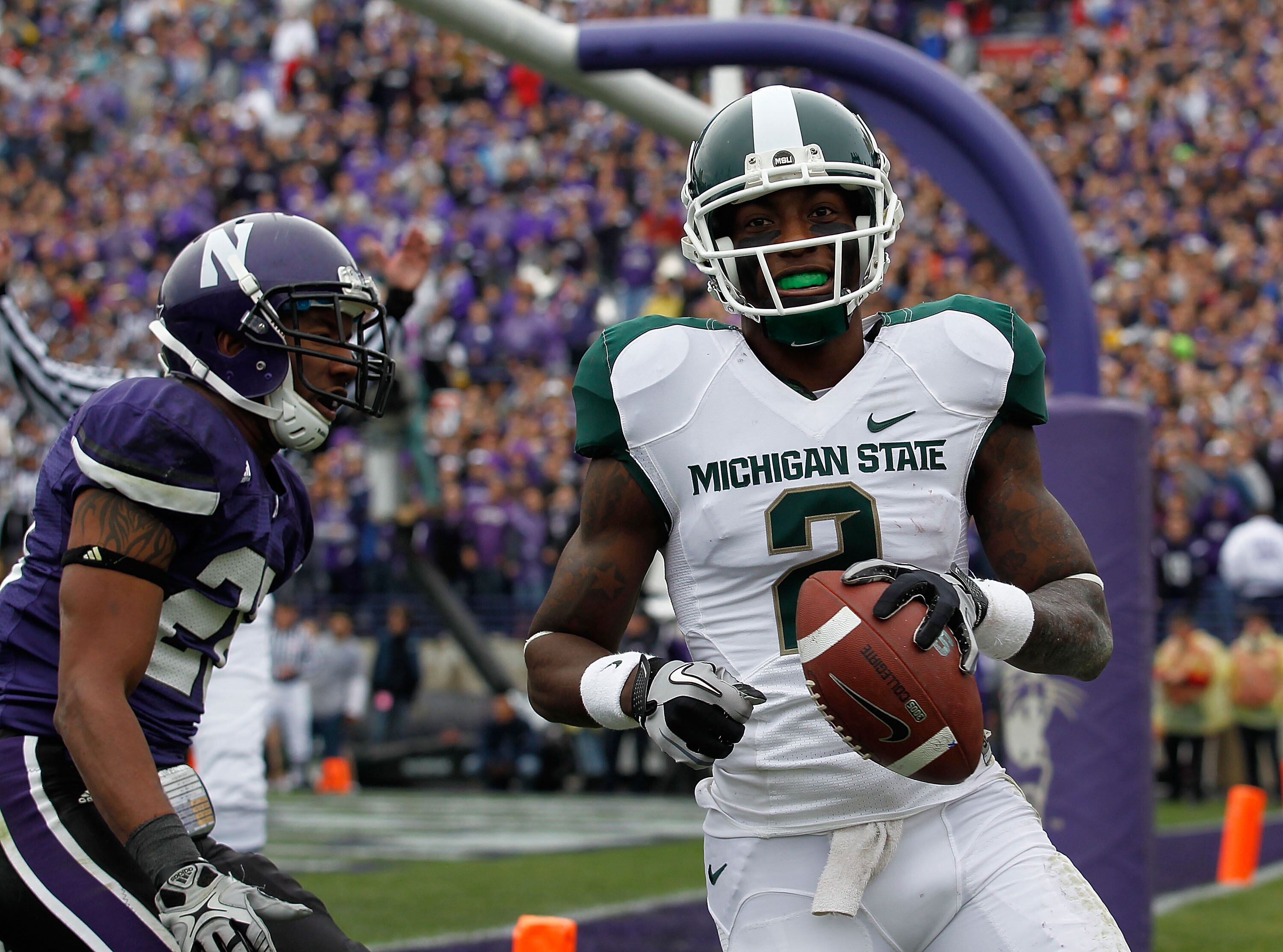 EVANSTON, IL - OCTOBER 23: Mark Dell #2 of the Michigan State Spartans scores a touchdown in front of Justan Vaughn #28 of the Northwestern Wildcats at Ryan Field on October 23, 2010 in Evanston, Illinois. Michigan State defeated Northwestern 35-27. (Phot