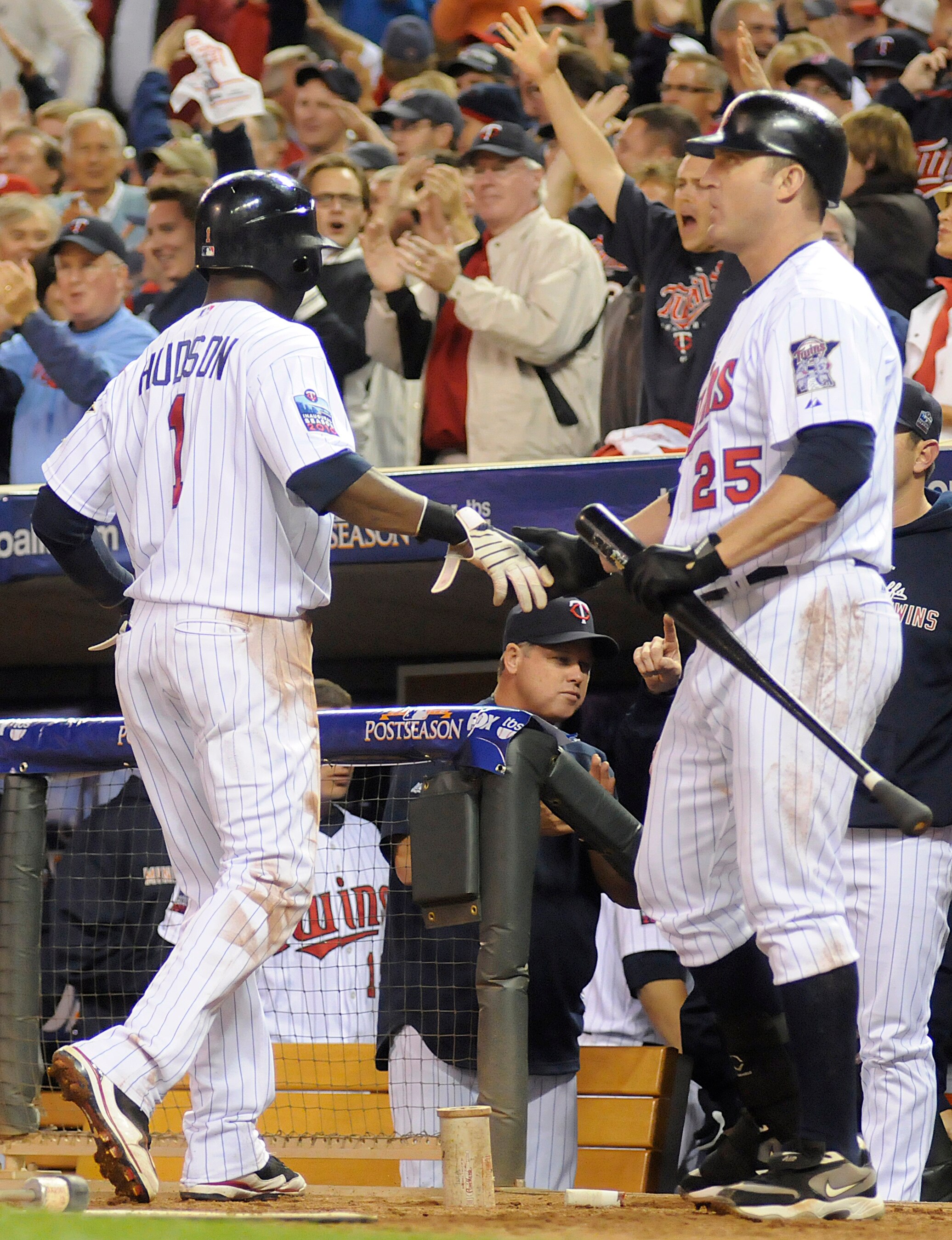 MINNEAPOLIS, MN - OCTOBER 6: Orlando Hudson #1 of the Minnesota Twins celebrates scoring on a passed ball in third inning with Jim Thome #25 during game one of the ALDS against the New York Yankees on October 6, 2010 at Target Field in Minneapolis, Minnes