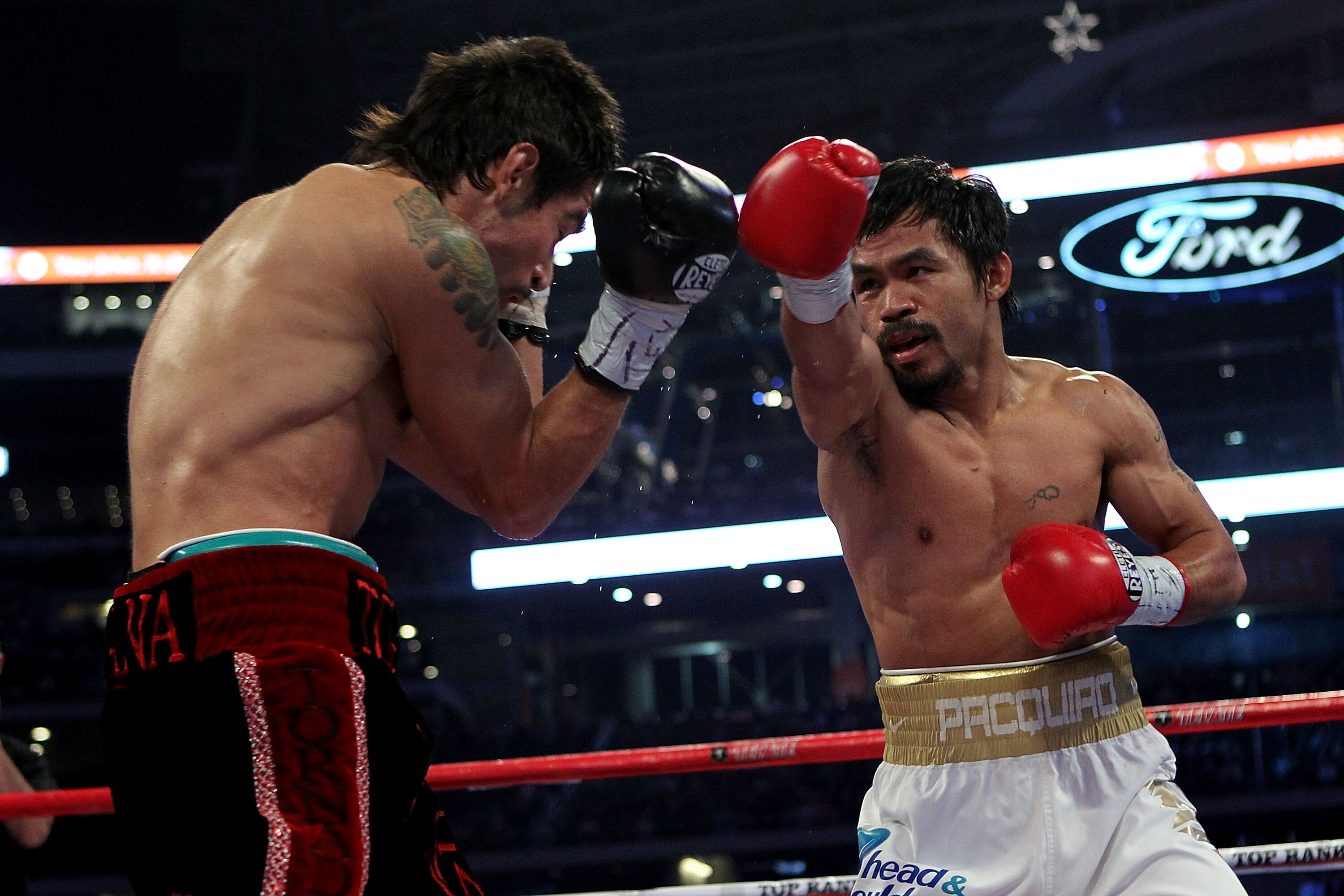 ARLINGTON, TX - NOVEMBER 13:  Manny Pacquiao (white trunks) of the Philippines throws a punch against Antonio Margarito (black trunks) of Mexico during their WBC World Super Welterweight Title bout at Cowboys Stadium on November 13, 2010 in Arlington, Tex