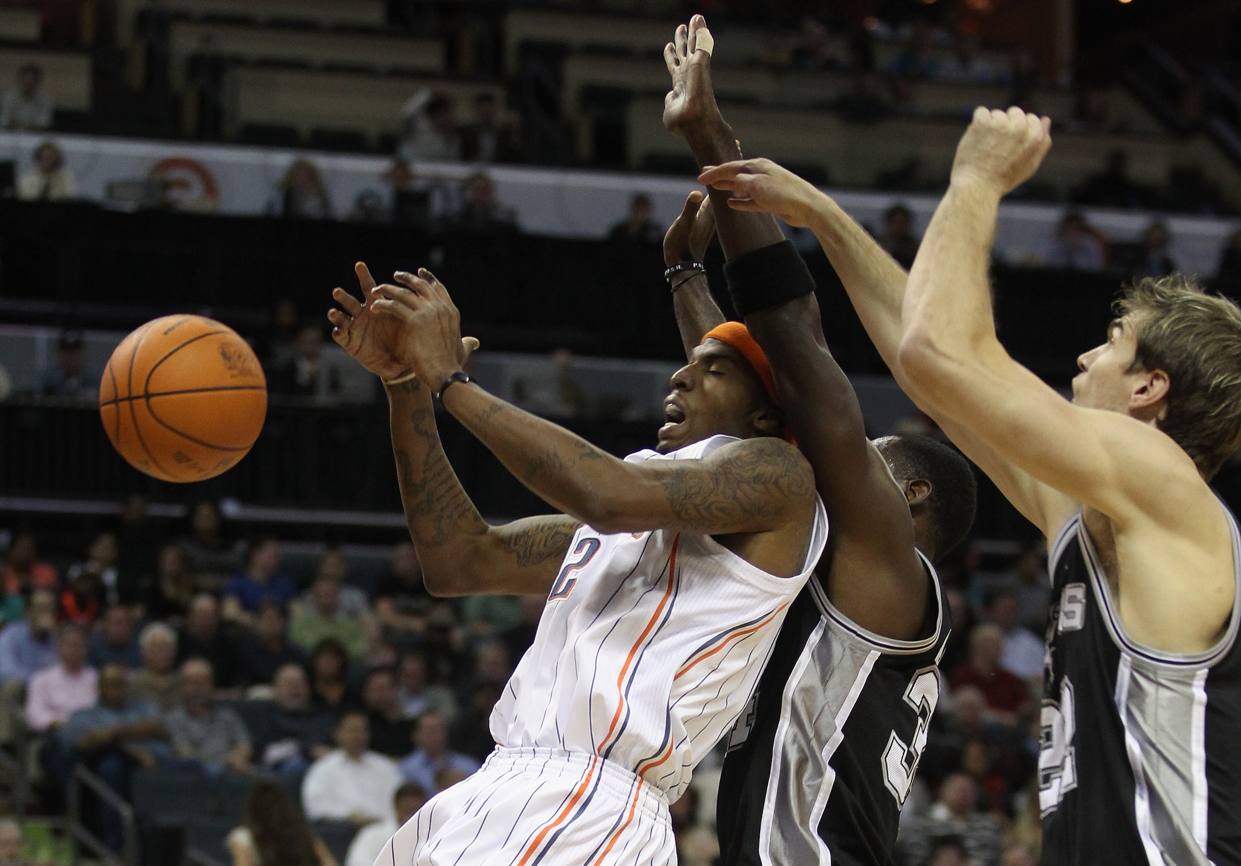 CHARLOTTE, NC - NOVEMBER 08:  Teammates Antonio McDyess #34 and Tiago Splitter #22 of the San Antonio Spurs collide with Tyrus Thomas #12 of the Charlotte Bobcats during their game at Time Warner Cable Arena on November 8, 2010 in Charlotte, North Carolin