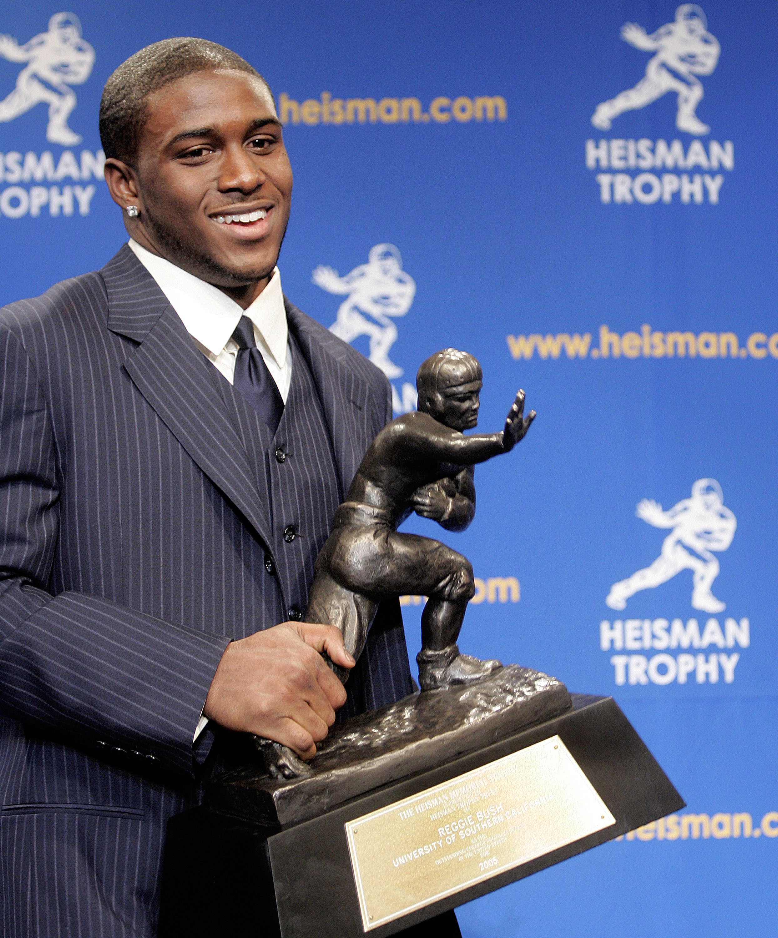 NEW YORK - DECEMBER 10:  Running back Reggie Bush #5 of the USC Trojans poses with the 2005 Heisman trophy after winning the award at the 71st Annual Heisman Ceremony on December 10, 2005 in New York City.  (Photo by Stephen Chernin/Getty Images)