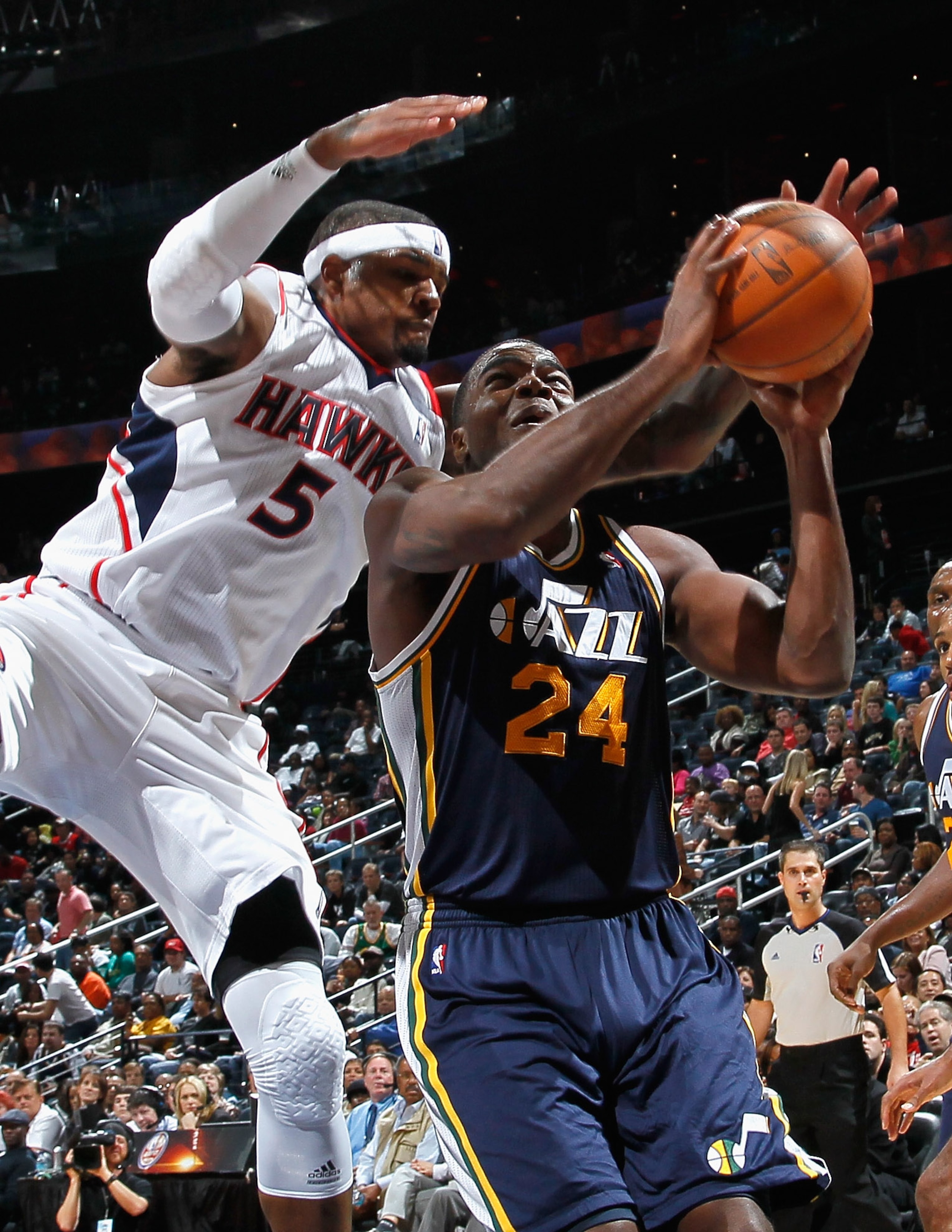 ATLANTA - NOVEMBER 12:  Paul Millsap #24 of the Utah Jazz is fouled by Josh Smith #5 of the Atlanta Hawks at Philips Arena on November 12, 2010 in Atlanta, Georgia.  NOTE TO USER: User expressly acknowledges and agrees that, by downloading and/or using th