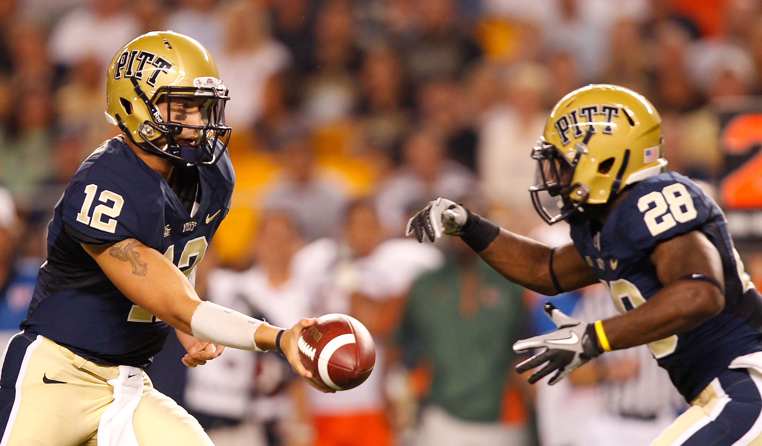 PITTSBURGH - SEPTEMBER 23:  Tino Sunseri #12 of the Pittsburgh Panthers hands the ball off to teammate Dion Lewis #28 during the game against the Miami Hurricanes on September 23, 2010 at Heinz Field in Pittsburgh, Pennsylvania.  (Photo by Jared Wickerham