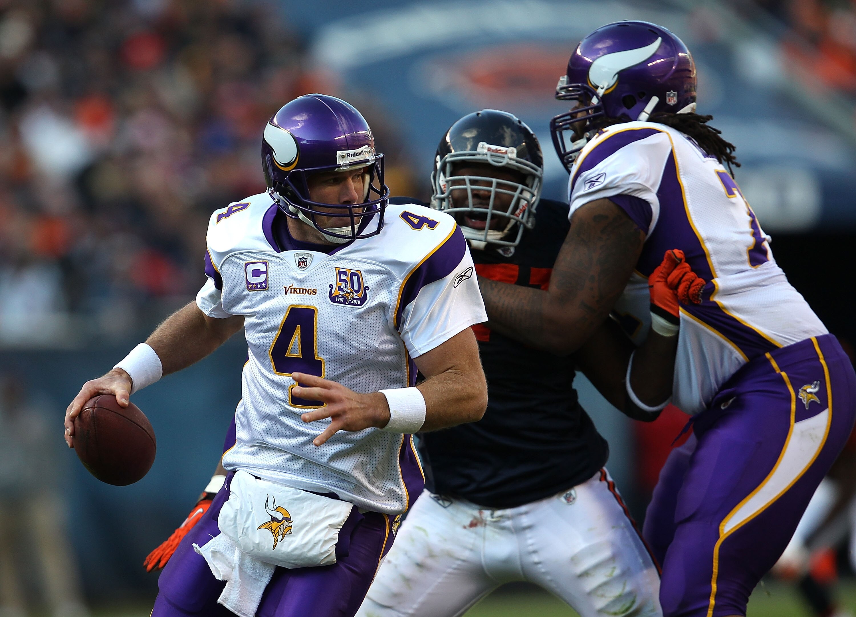CHICAGO - NOVEMBER 14: Brett Favre #4 of the Minnesota Vikings turns to avoid the rush of Israel Idonije #71 of the Chicago Bears who is held by Phil Loadholt #71 at Soldier Field on November 14, 2010 in Chicago, Illinois. The Bears defeated the Vikings 2