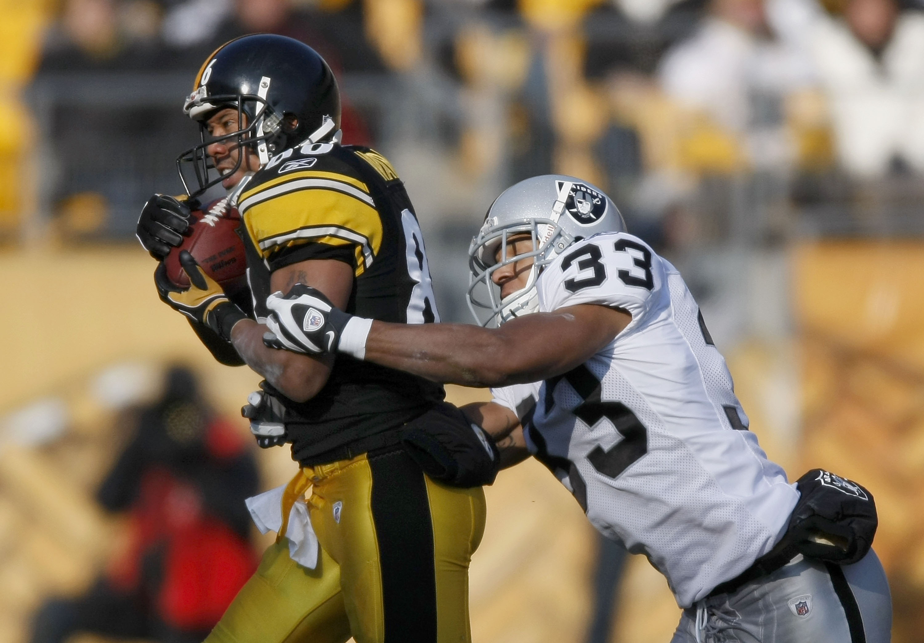 PITTSBURGH - DECEMBER 06:  Hines Ward #86 of the Pittsburgh Steelers catches a second quarter pass in front of Tyvon Branch #33 of the Oakland Raiders December 6, 2009 at Heinz Field in Pittsburgh, Pennsylvania. Oakland won the game 27-24.  (Photo by Greg