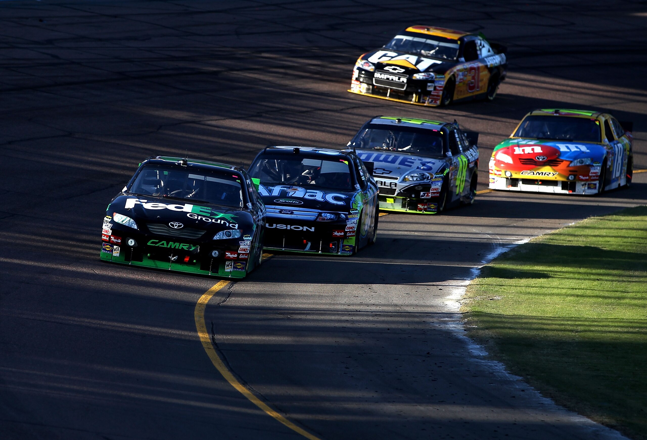 AVONDALE, AZ - NOVEMBER 14: Denny Hamlin, driver of the #11 FedEx Toyota, leads Carl Edwards, driver of the #99 Aflac Ford, Jimmie Johnson, driver of the #48 Lowe's Chevrolet, and Kyle Busch, driver of the #18 M&M'sToyota, during the NASCAR Sprint Cup Se AVONDALE, AZ - NOVEMBER 14: Denny Hamlin, driver of the #11 FedEx Toyota, leads Carl Edwards, driver of the #99 Aflac Ford, Jimmie Johnson, driver of the #48 Lowe's Chevrolet, and Kyle Busch, driver of the #18 M&M'sToyota, during the NASCAR Sprint Cup Se