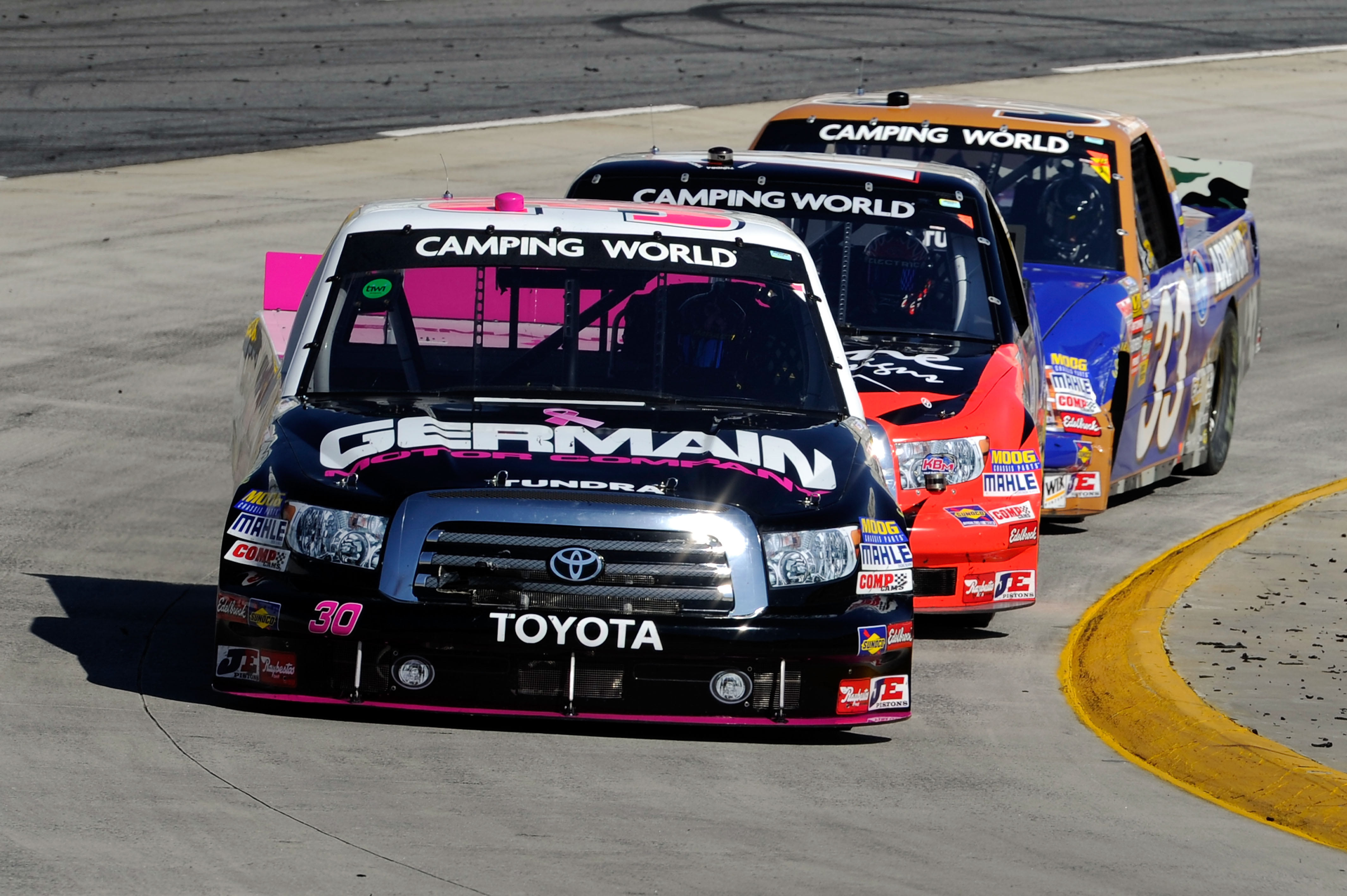 MARTINSVILLE, VA - OCTOBER 23: Todd Bodine, driver of the #30 Germain.com Toyota, leads Kyle Busch, driver of the #18 Tundra/Z-Line Designs Toyota, and Ron Hornaday Jr., driver of the #33 Armour Vienna Sausage/Kroger Chevrolet, during the NASCAR Camping W