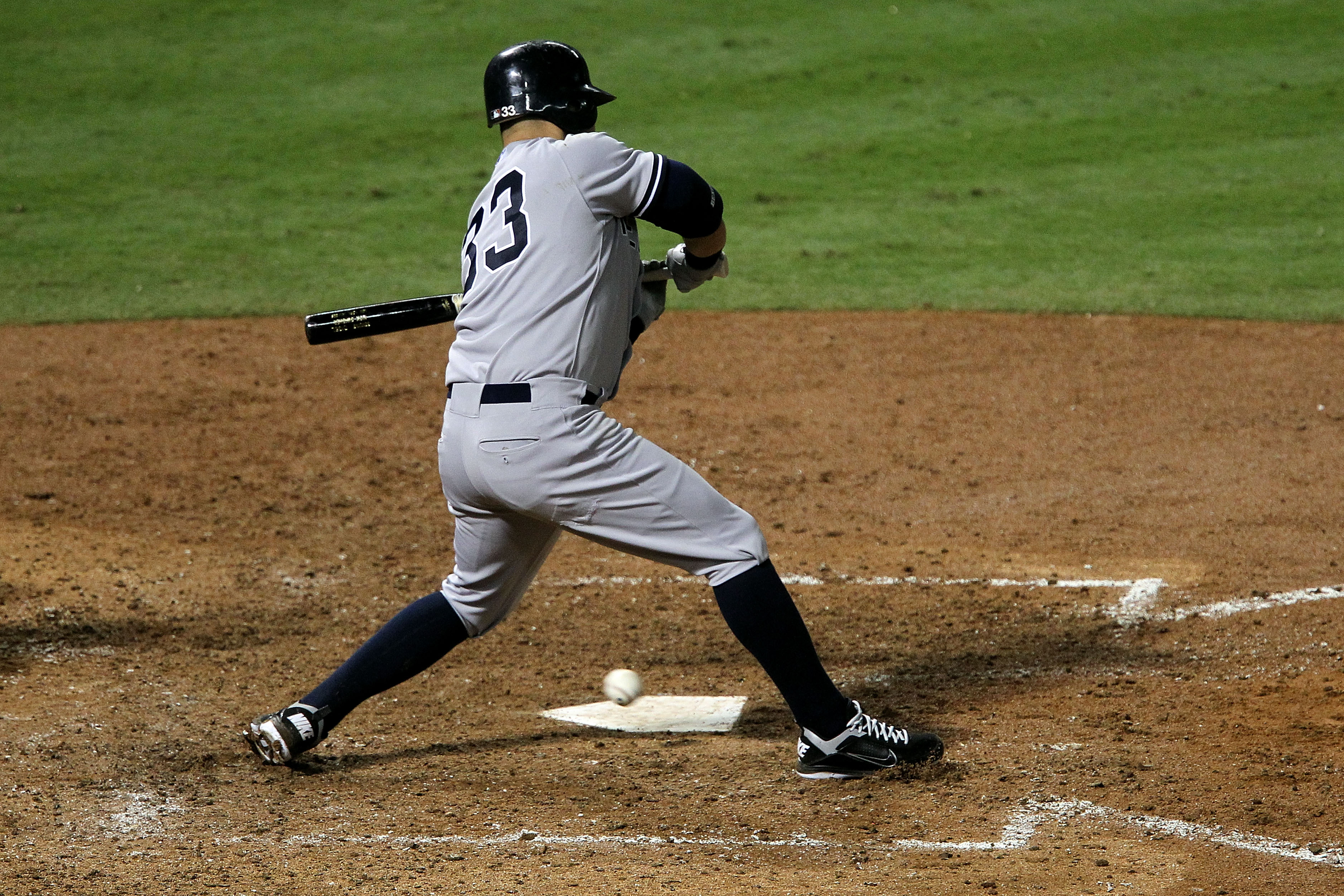 ARLINGTON, TX - OCTOBER 22:  Nick Swisher #33 of the New York Yankees checks his swing on a wild pitch from Colby Lewis #48 of the Texas Rangers in the fifth inning of Game Six of the ALCS during the 2010 MLB Playoffs at Rangers Ballpark in Arlington on O