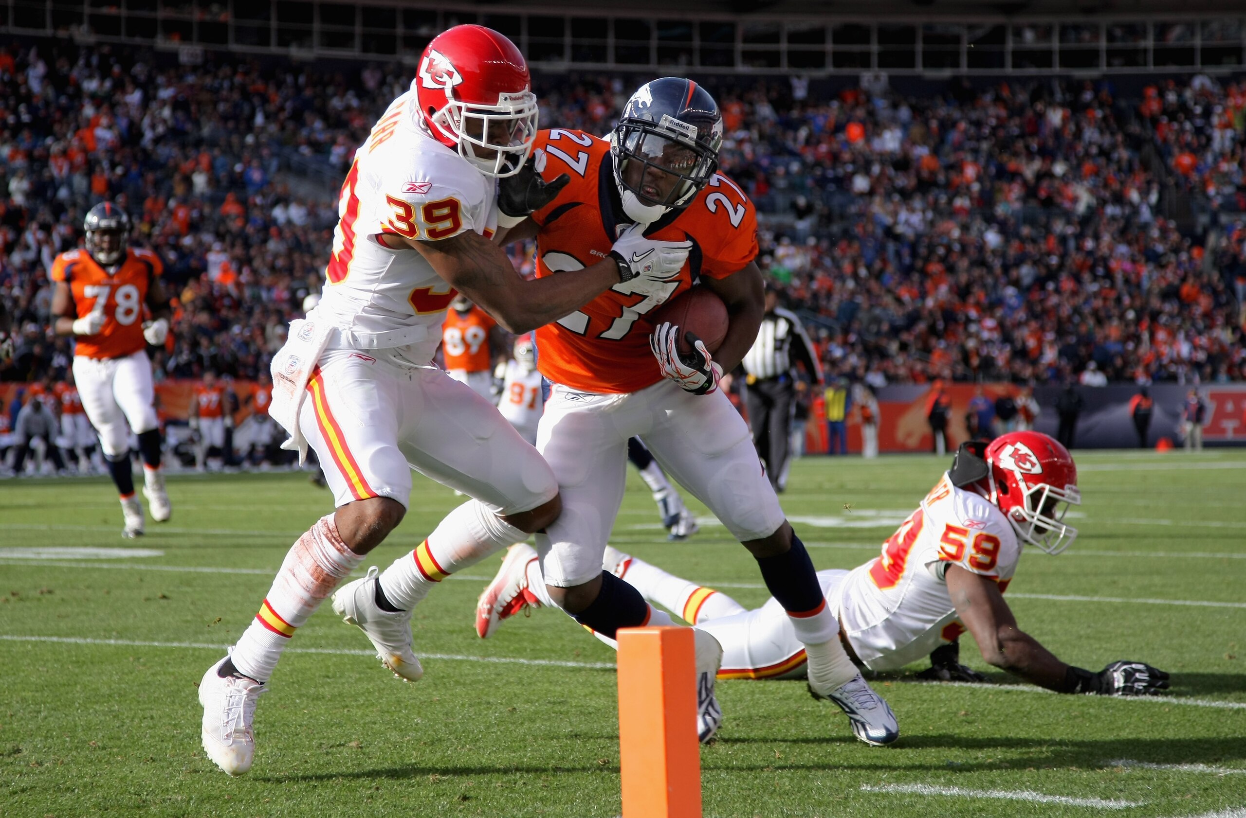 DENVER - NOVEMBER 14:  Running back Knowshon Moreno #27 of the Denver Broncos makes a 17 yard pass reception and fights his way past cornerback Brandon Carr #39 of the Kansas City Chiefs for a first quarter touchdown at INVESCO Field at Mile High on Novem